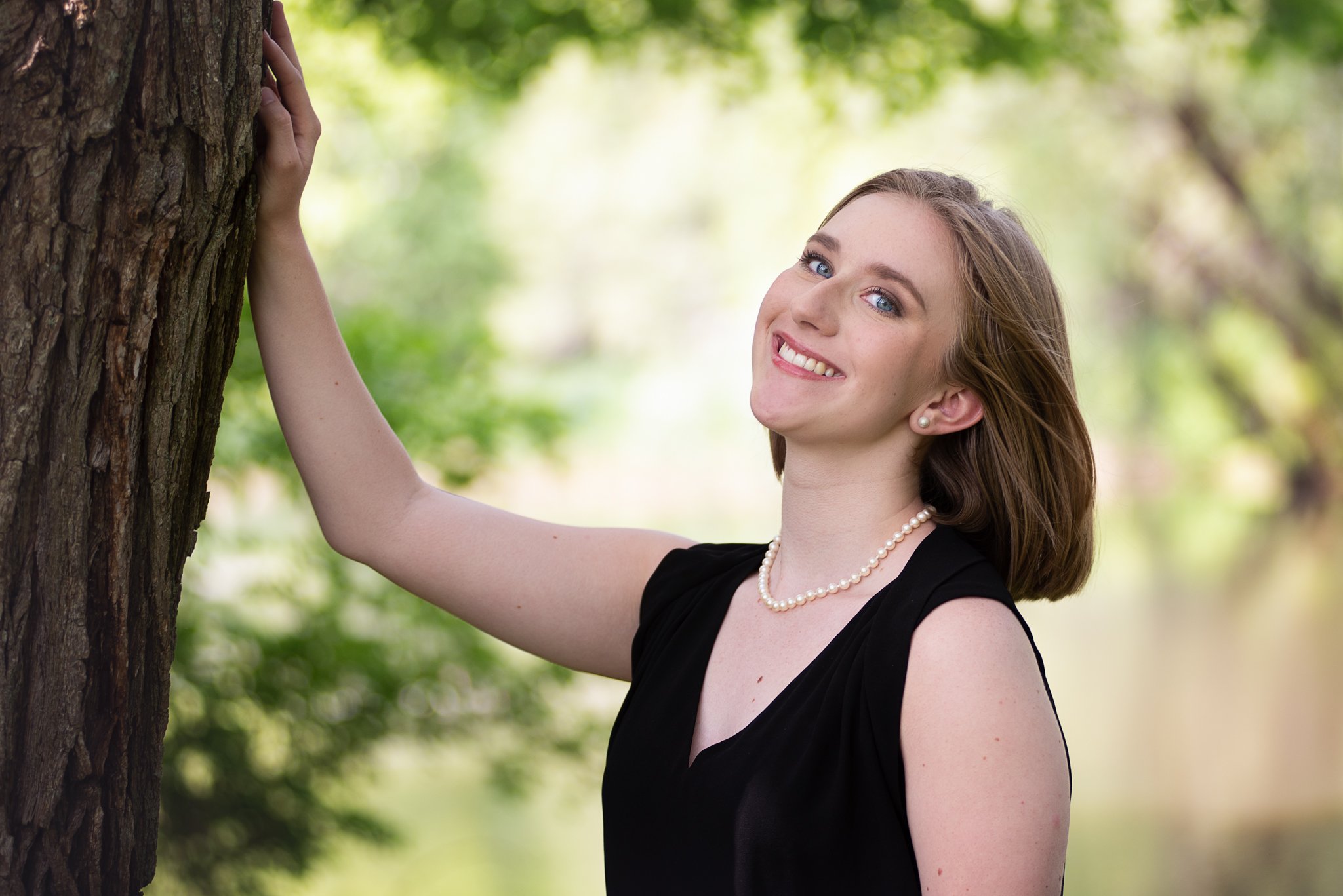 senior posing near a tree