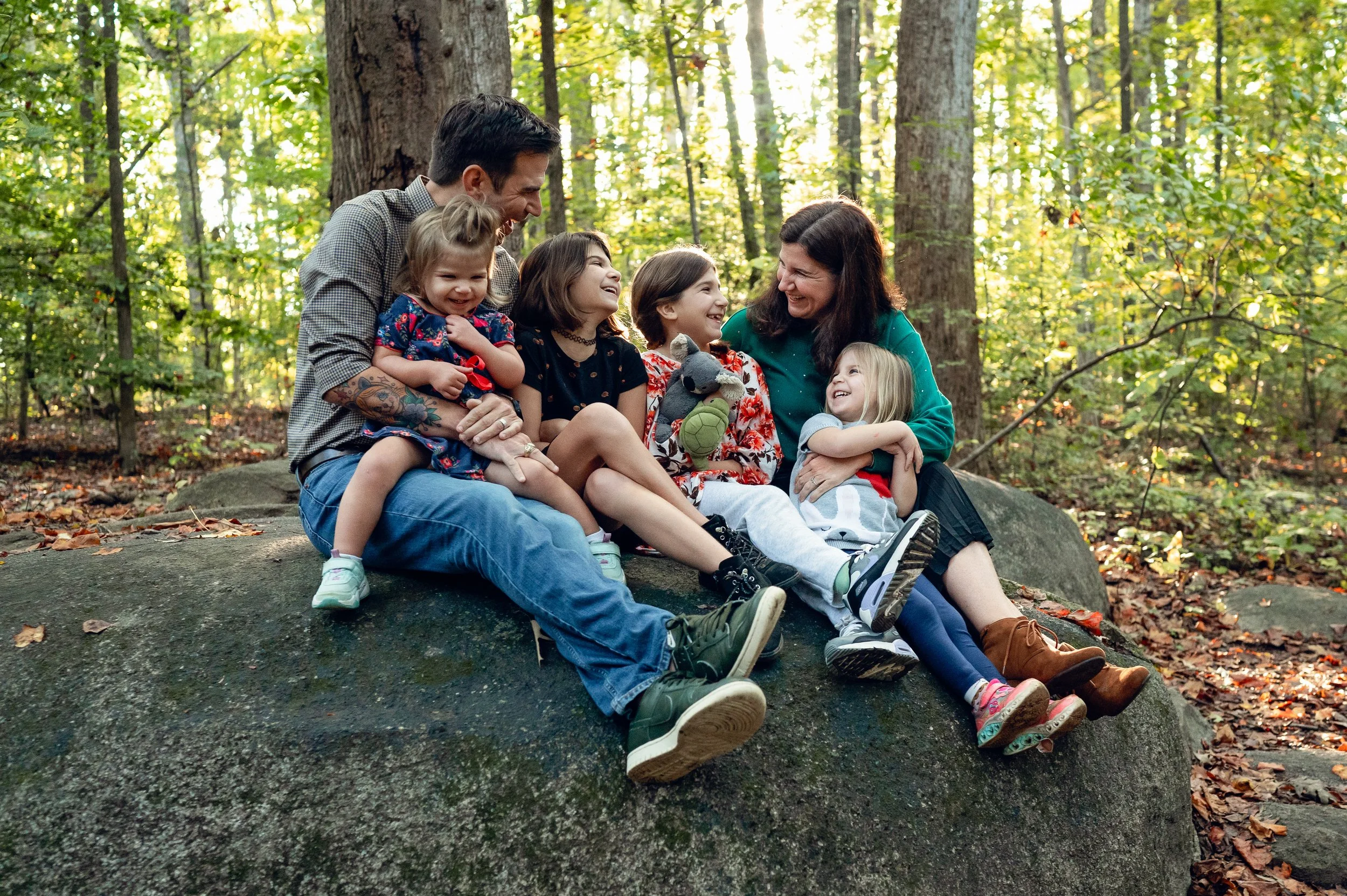 family laughing together during family photo session at big rock nature preserve, charlotte, nc