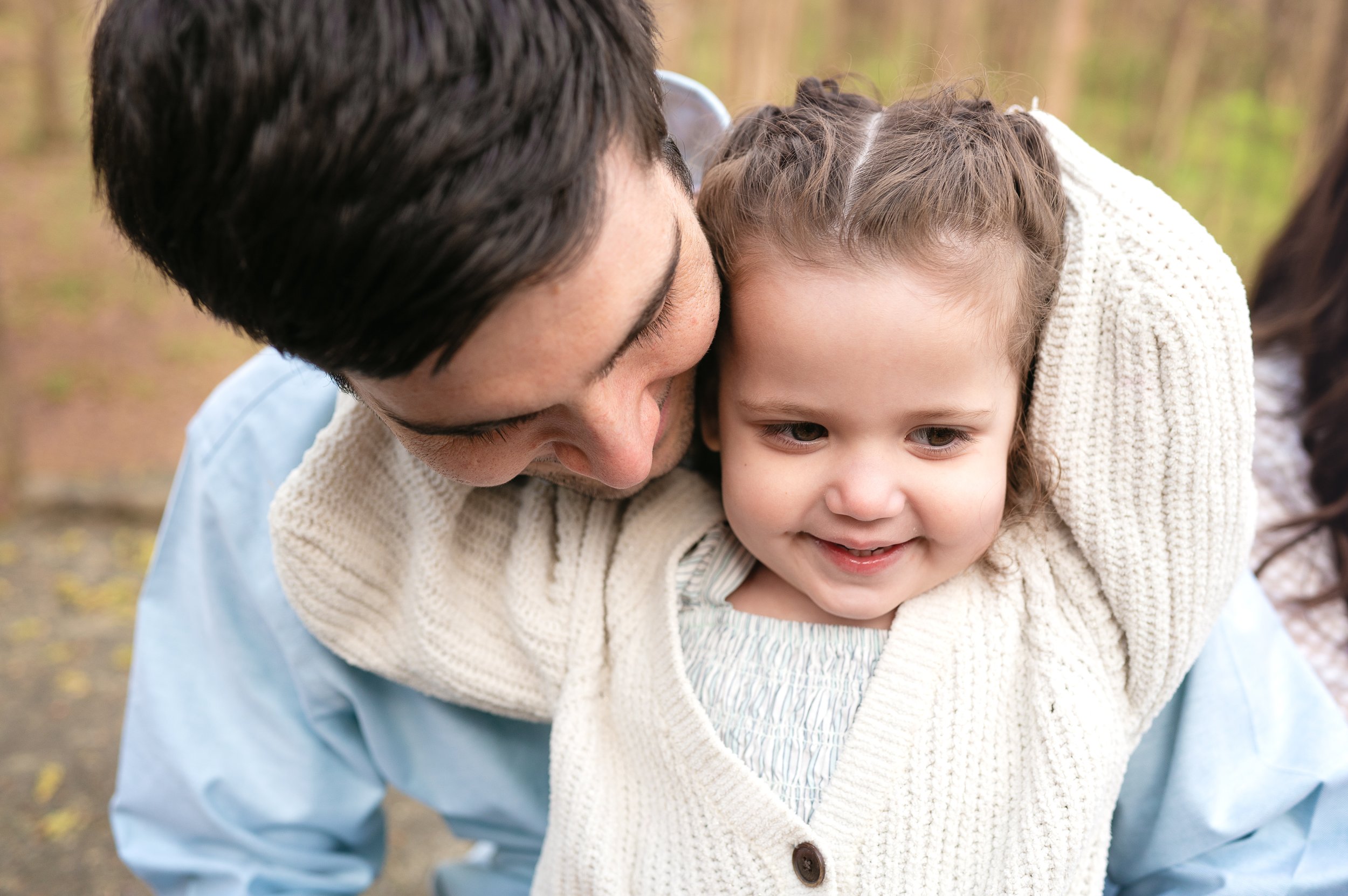 Dad and daughter cuddling together during family photo session, charlotte, nc