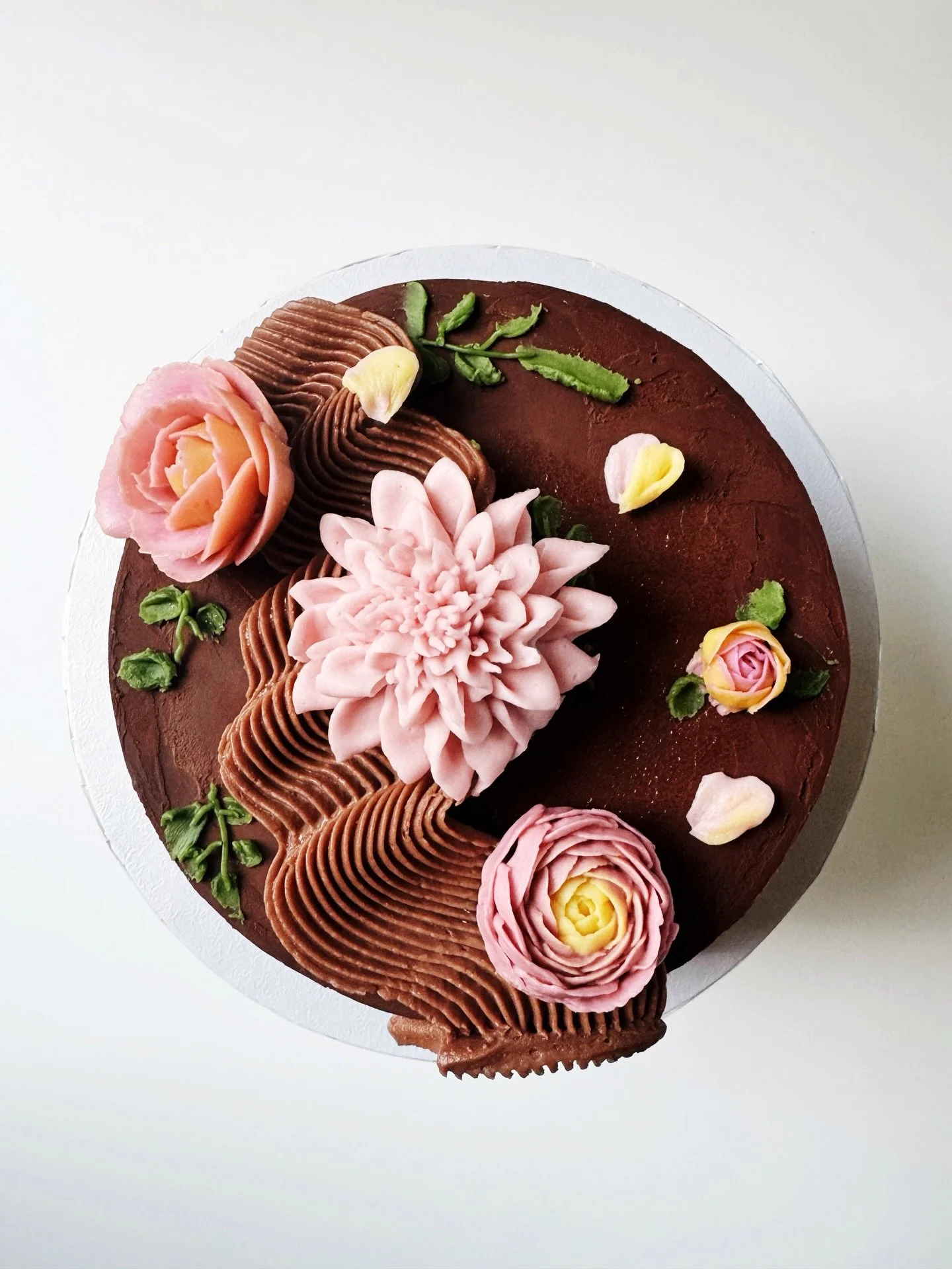 Chocolate cake with chocolate ganache for @knga&rsquo;s birthday! 🥳

It took me a few iterations to get the flower colors and arrangement just right (scroll through to see some early fails 🫠), and it was my first crack at the &ldquo;squiggle&rdquo;
