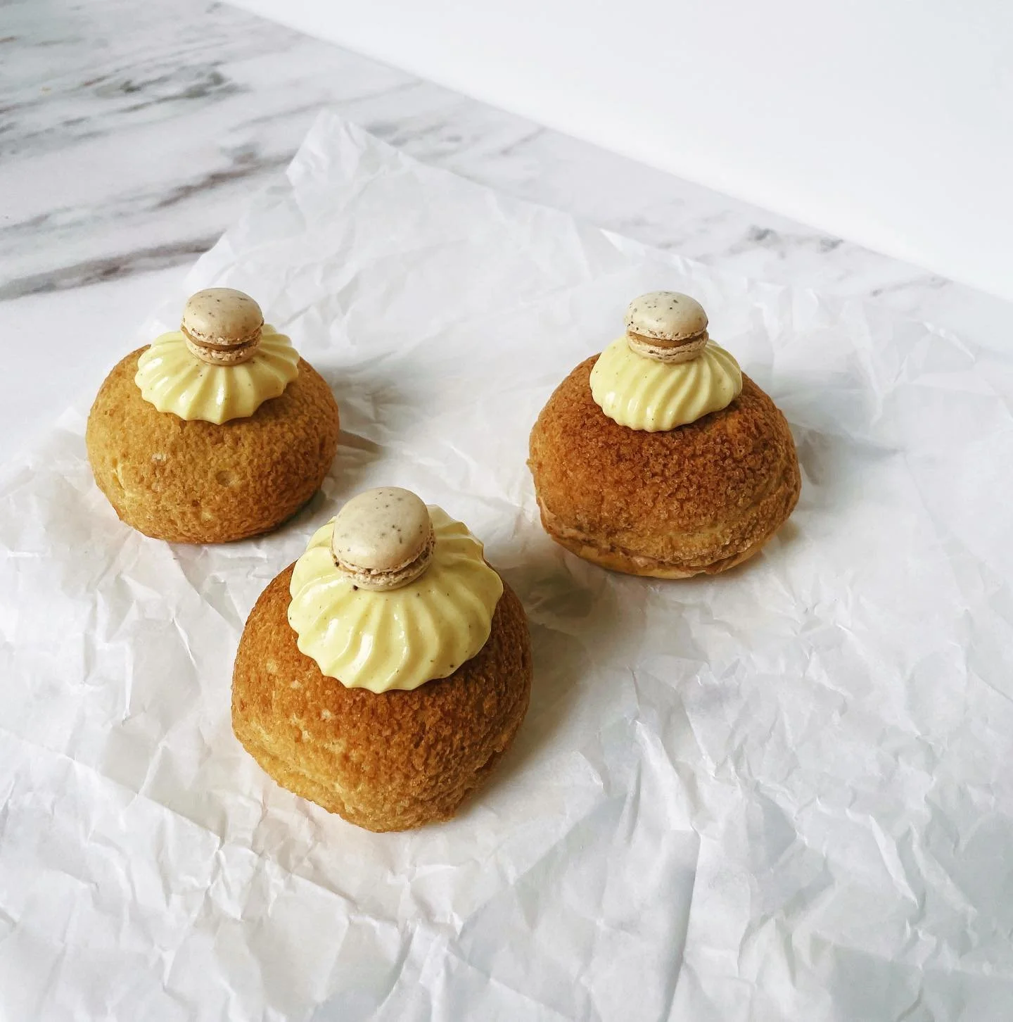 Choux buns with earl grey whipped filling, Meyer lemon cream cheese pastry cream, and earl grey mini macarons
