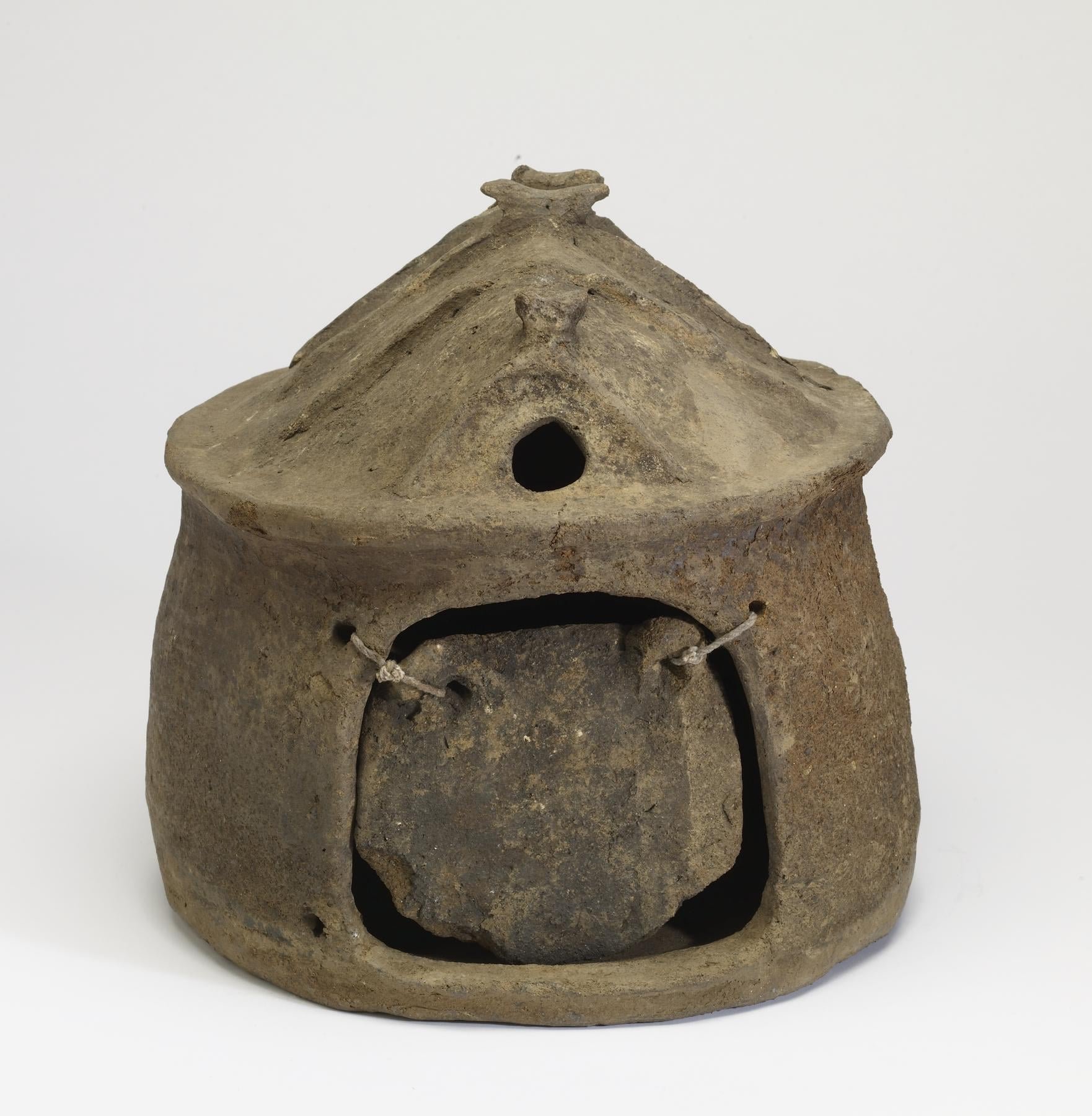 an ancient funeral urn in the style of a hut home