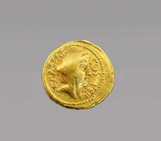 an ancient gold Roman coin with a veiled goddess