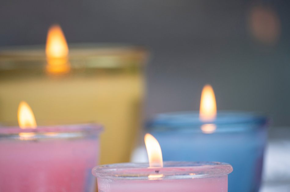 yellow, pink and blue candles in glass votives