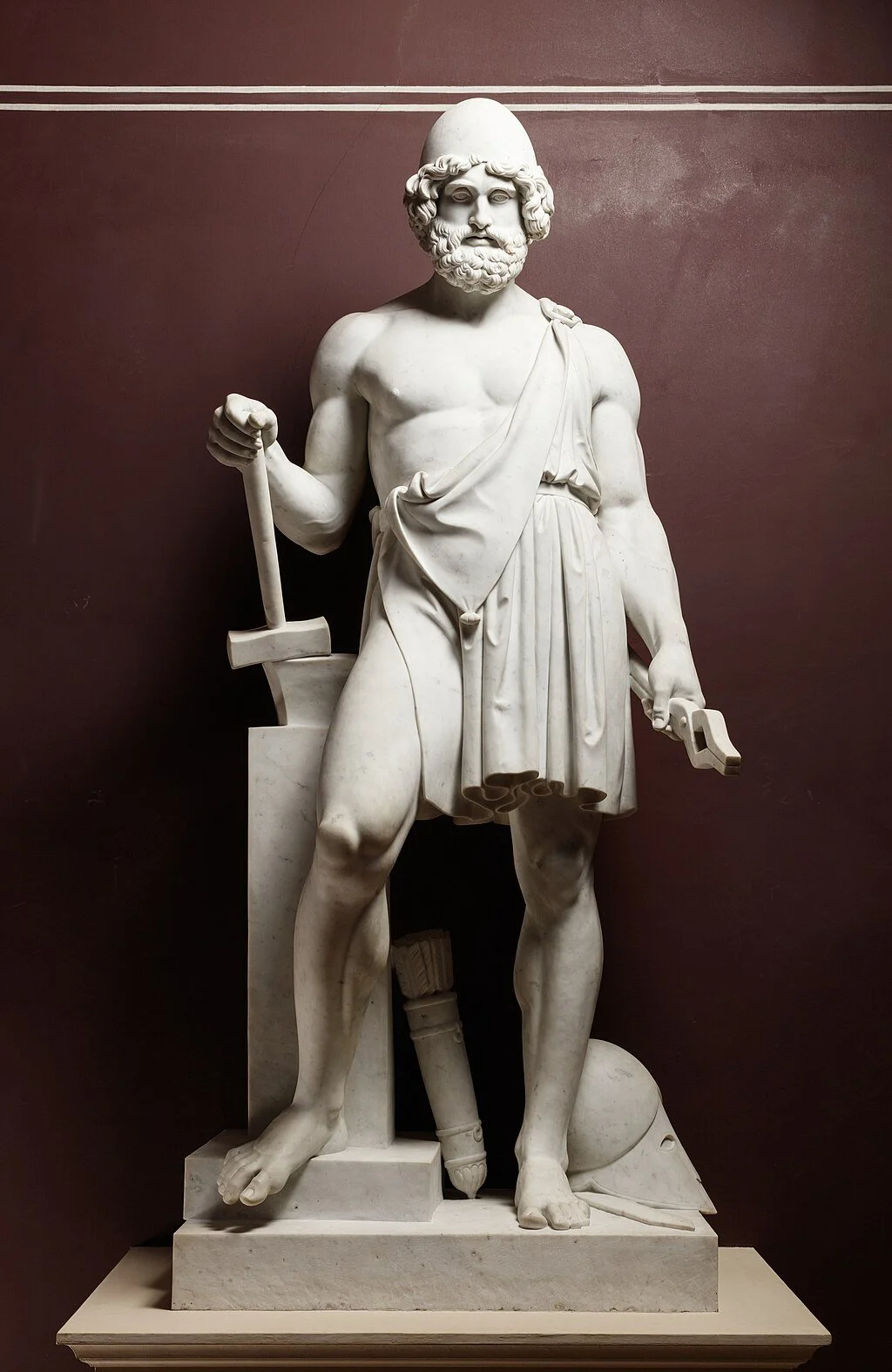 marble statue of a god holding blacksmith tools