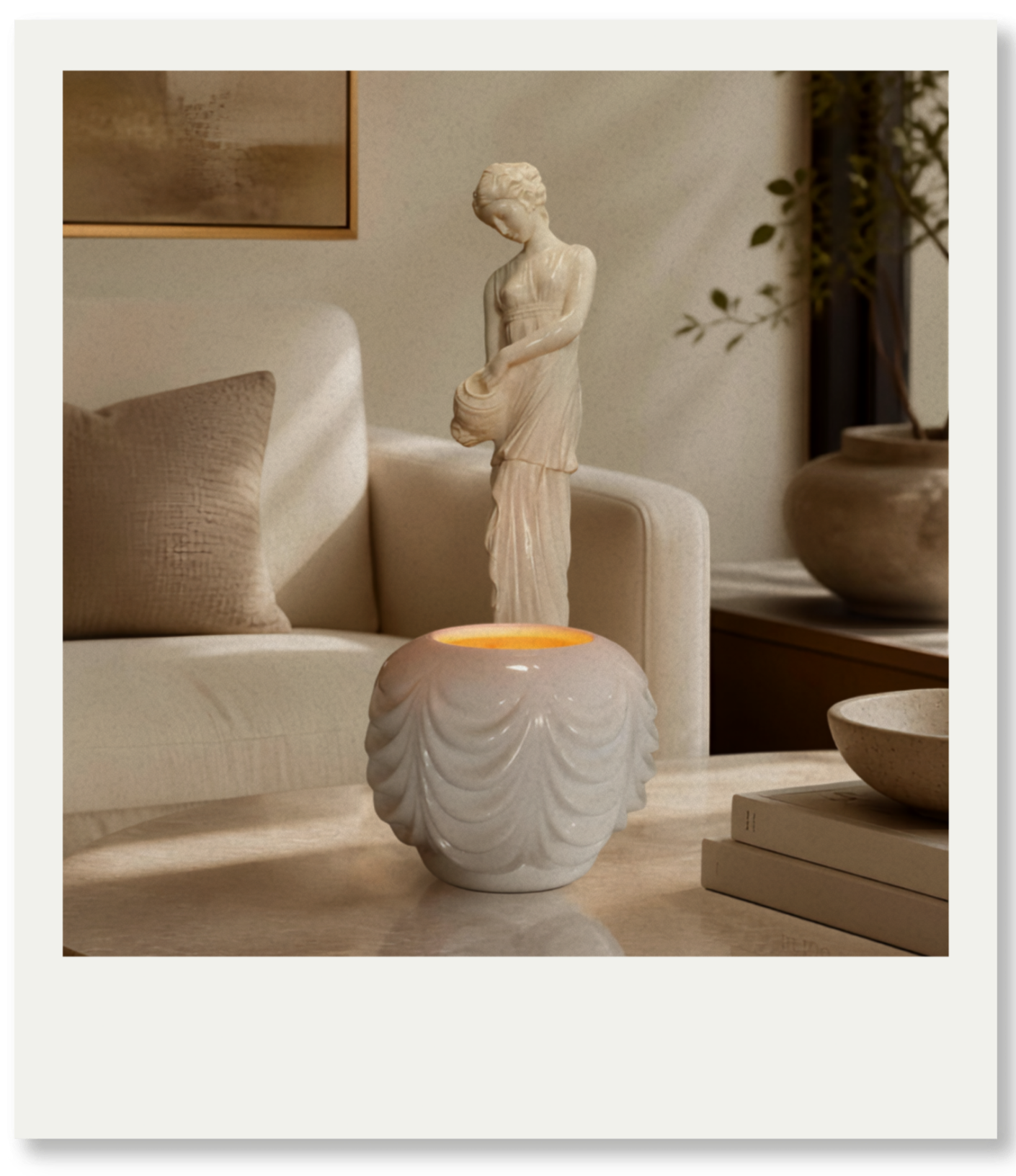 A decorative ceramic sculpture of a woman holding an object, placed on a table in a living room. There are other decorative items like bowls and a book nearby, with a sofa and cushions in the background.