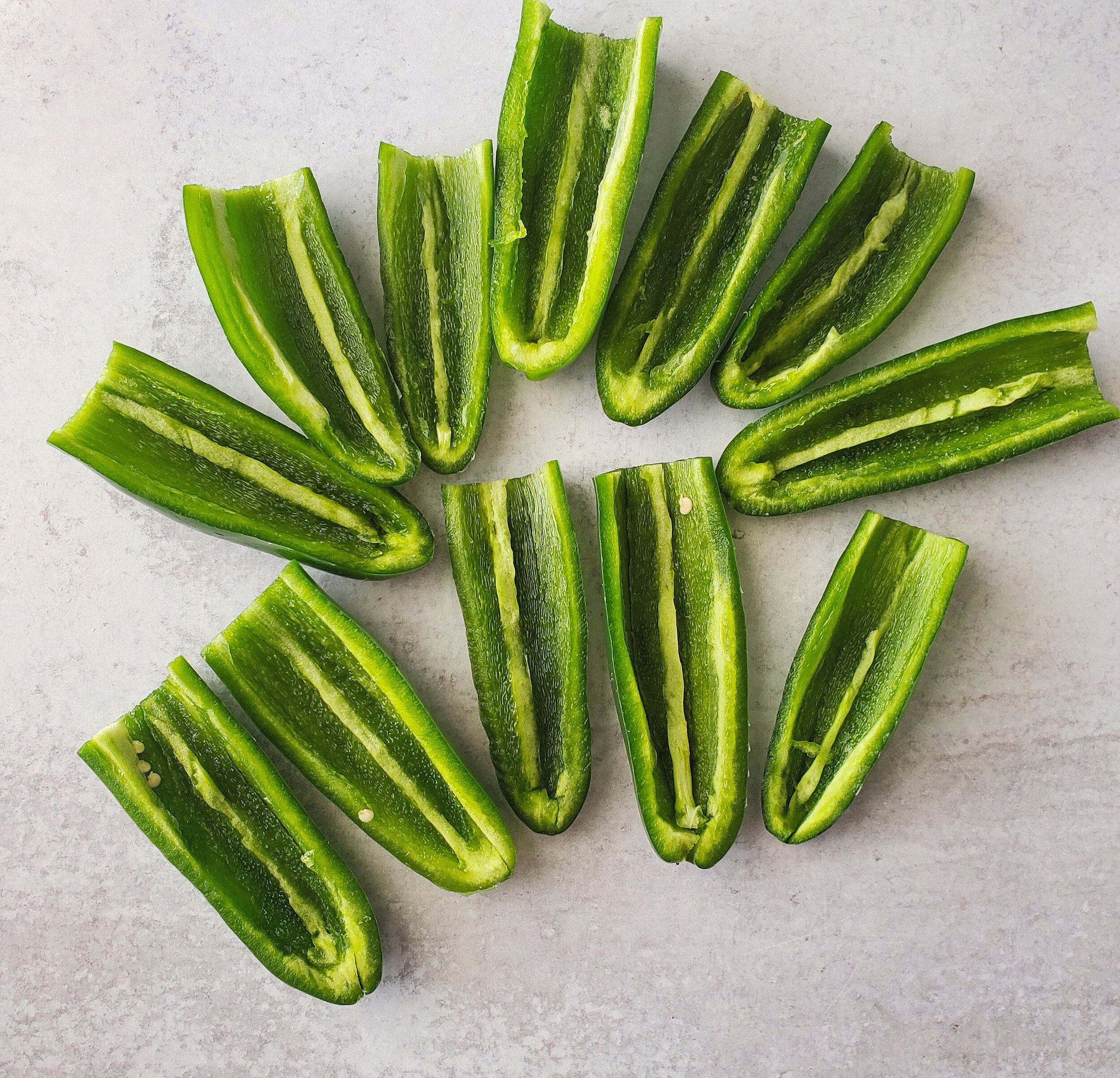 Cut the jalapenos vertically in half. Then remove the center/seed with a knife. - 