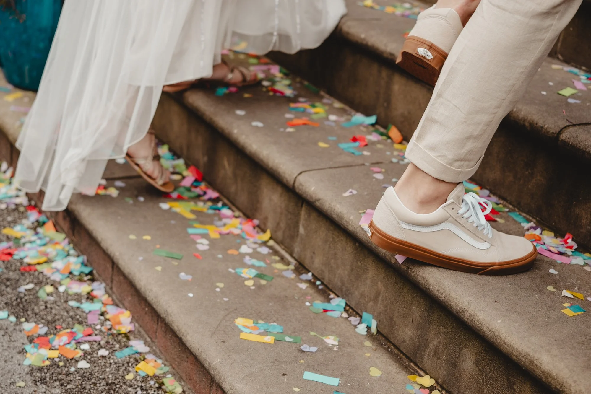 photograph of a bride and groom's feed as they walk up steps covered in confetti
