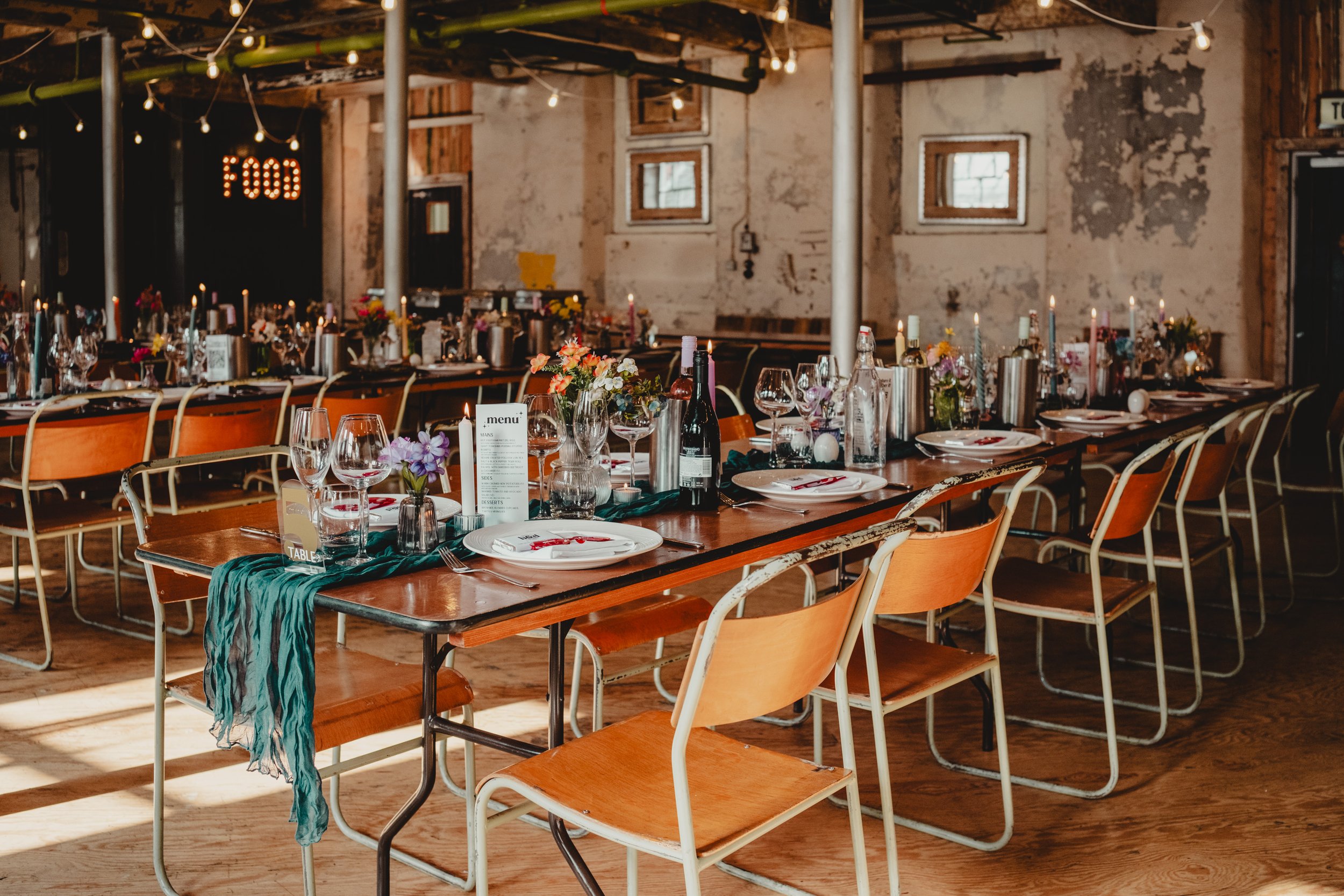 Photograph of the main wedding space set up with colourful table decorations at Holmes Mill, a wedding venue in the North West
