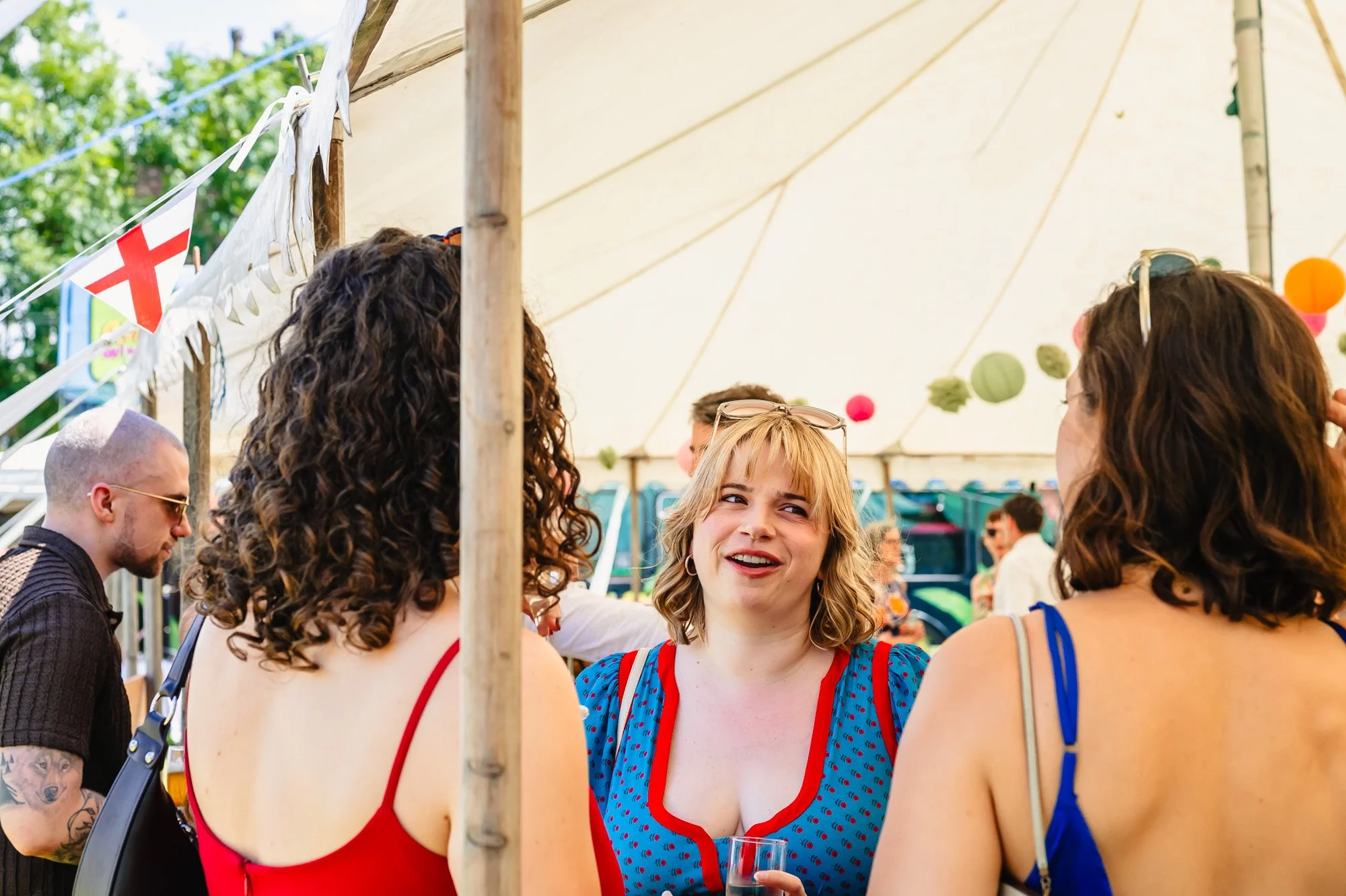  Three women talking in a marquee 