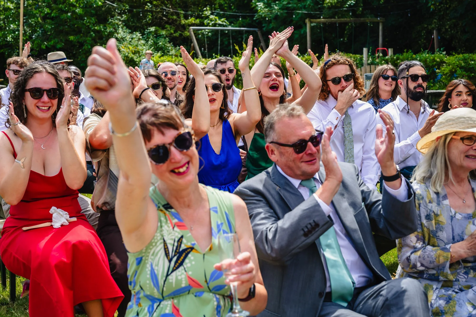  wedding guests cheer at an outdoor ceremony in Manchester 