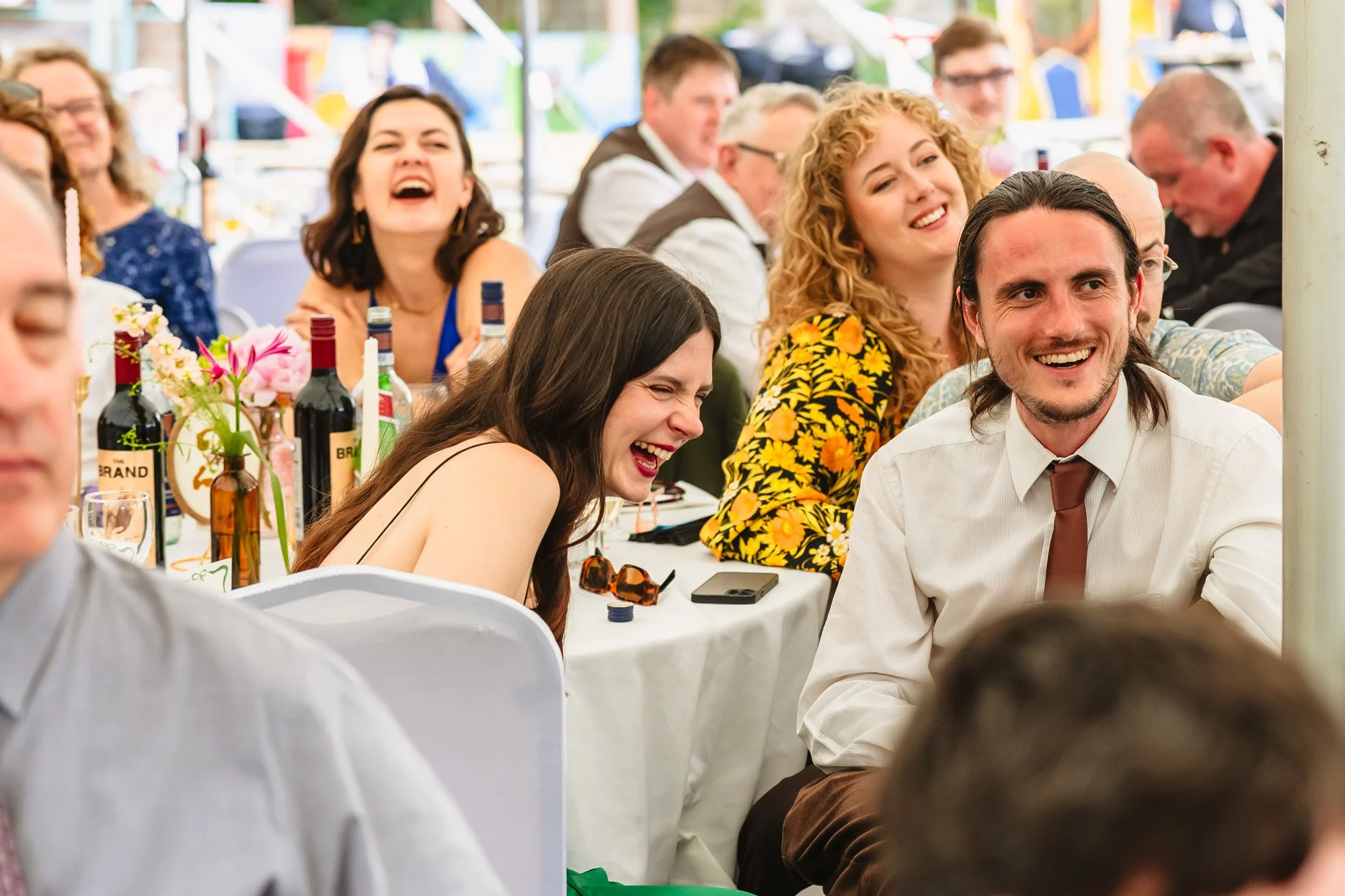  Wedding guests laugh during speeches. 