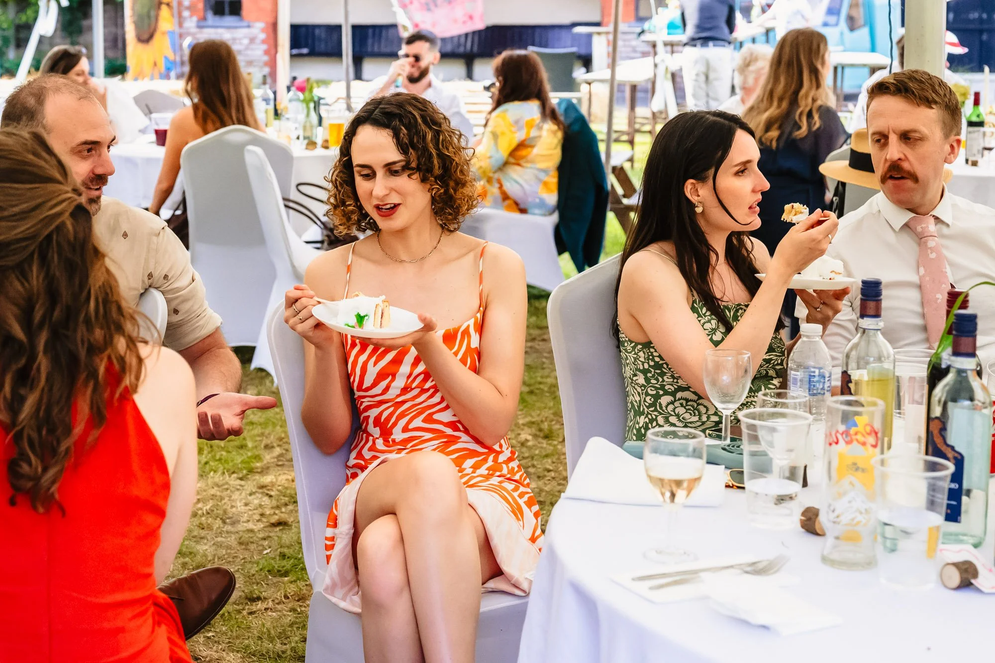  Wedding guests in a marquee eat cake 