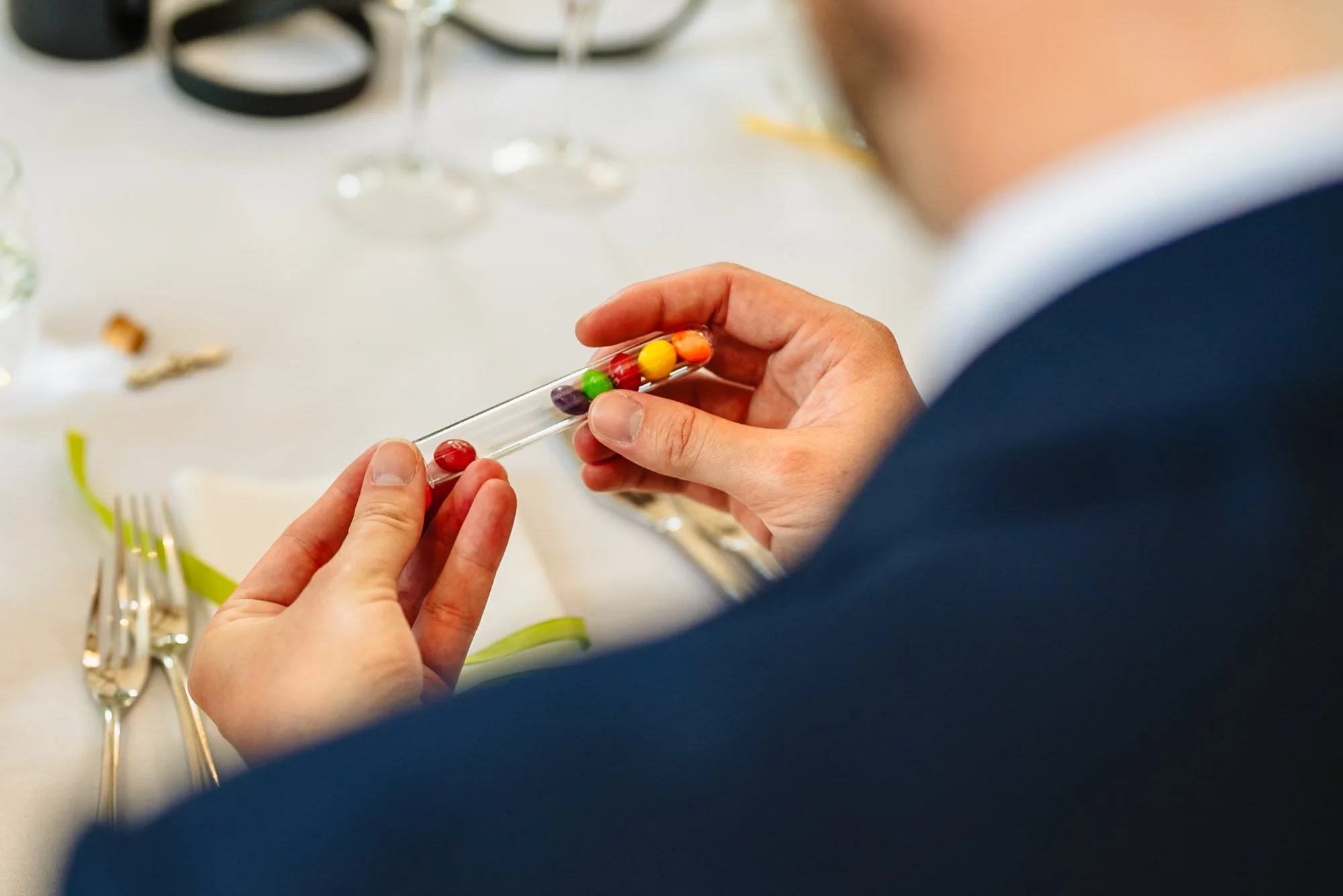 a man takes skittles from a tube - an idea for a sustainable wedding favour