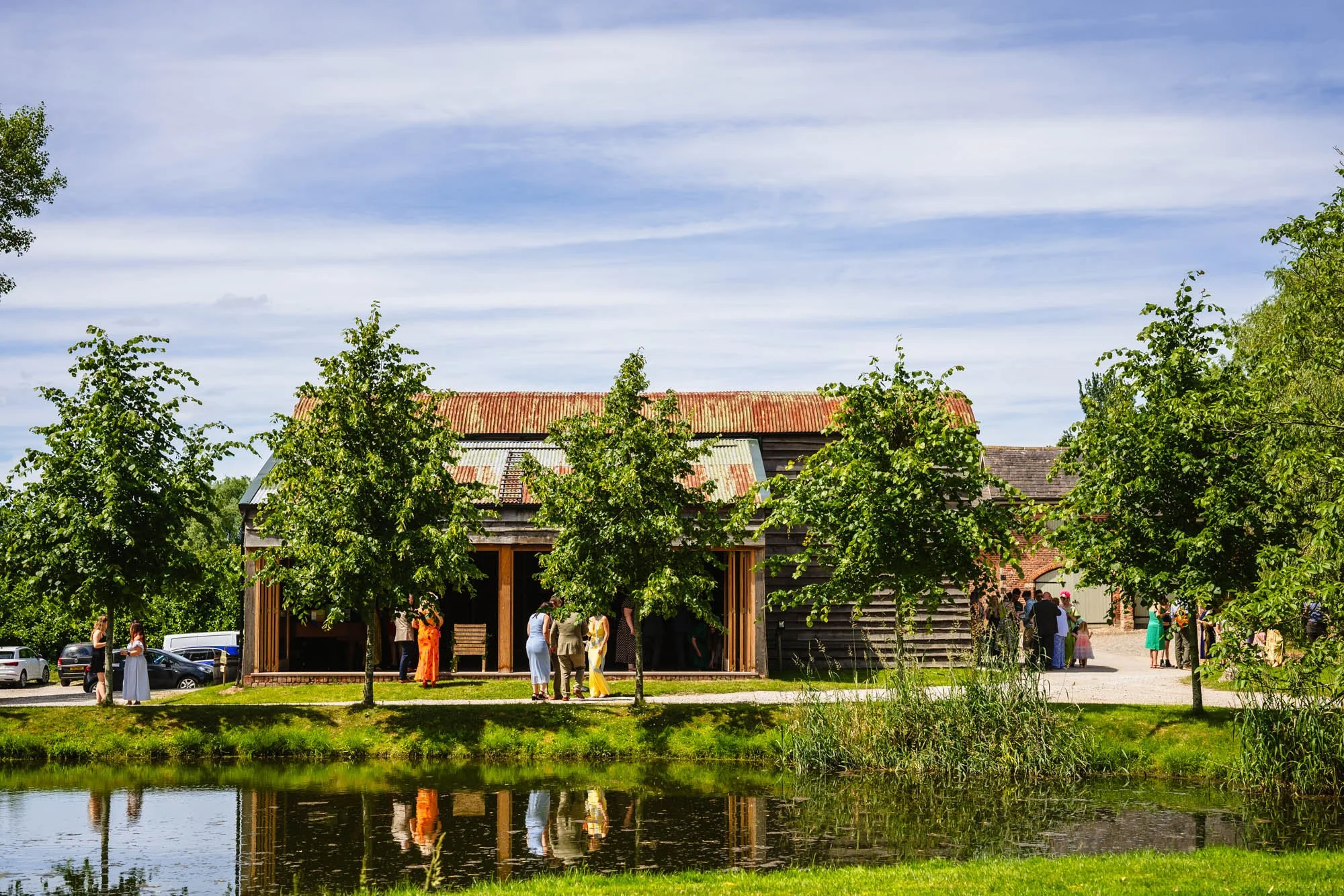 photograph of the lake and barn at Duddon Mill Farm, image included in a list of sustainable wedding venues in England
