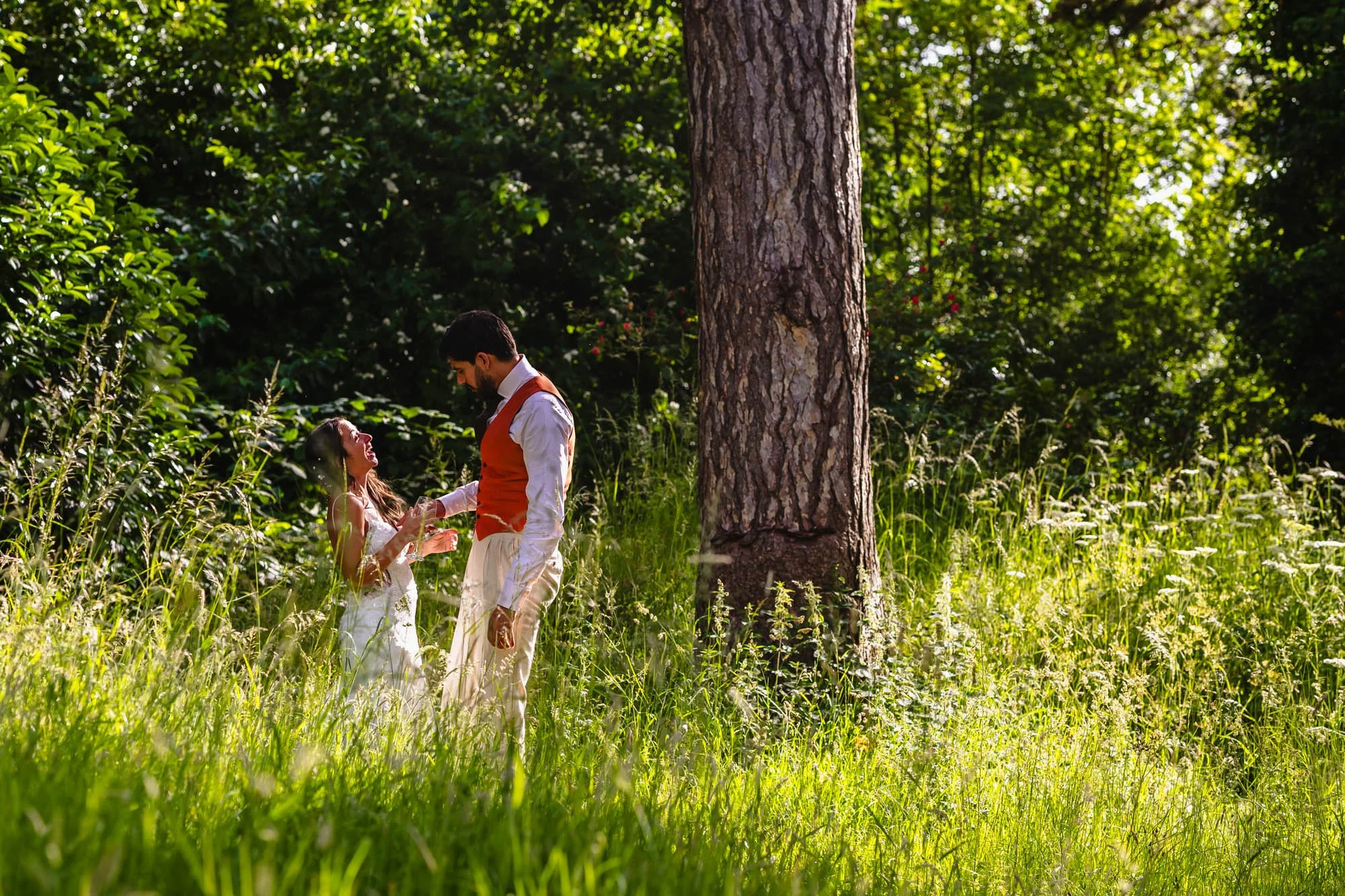 a newly married couple enjoy a peaceful moment in a sunlit woodland during their wedding reception at tipis at whatton house by documentary wedding photographer Caroline Goosey