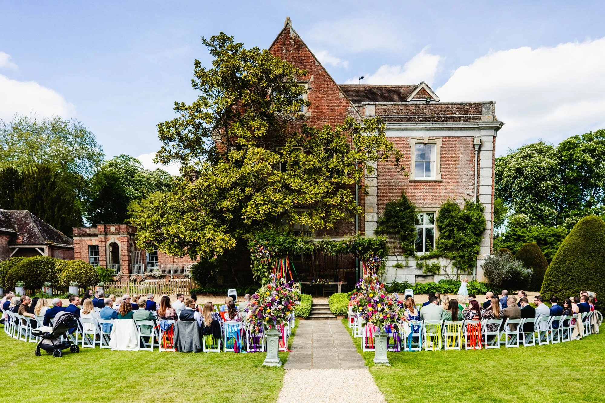 a photograph of a wedding ceremony about to happen outside on the lawn at Dean's Court in Wimborne