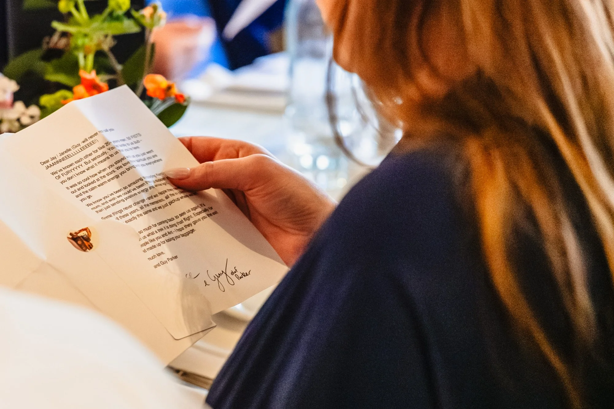 a wedding guest reads her wedding favour - a personal letter from the bride and groom