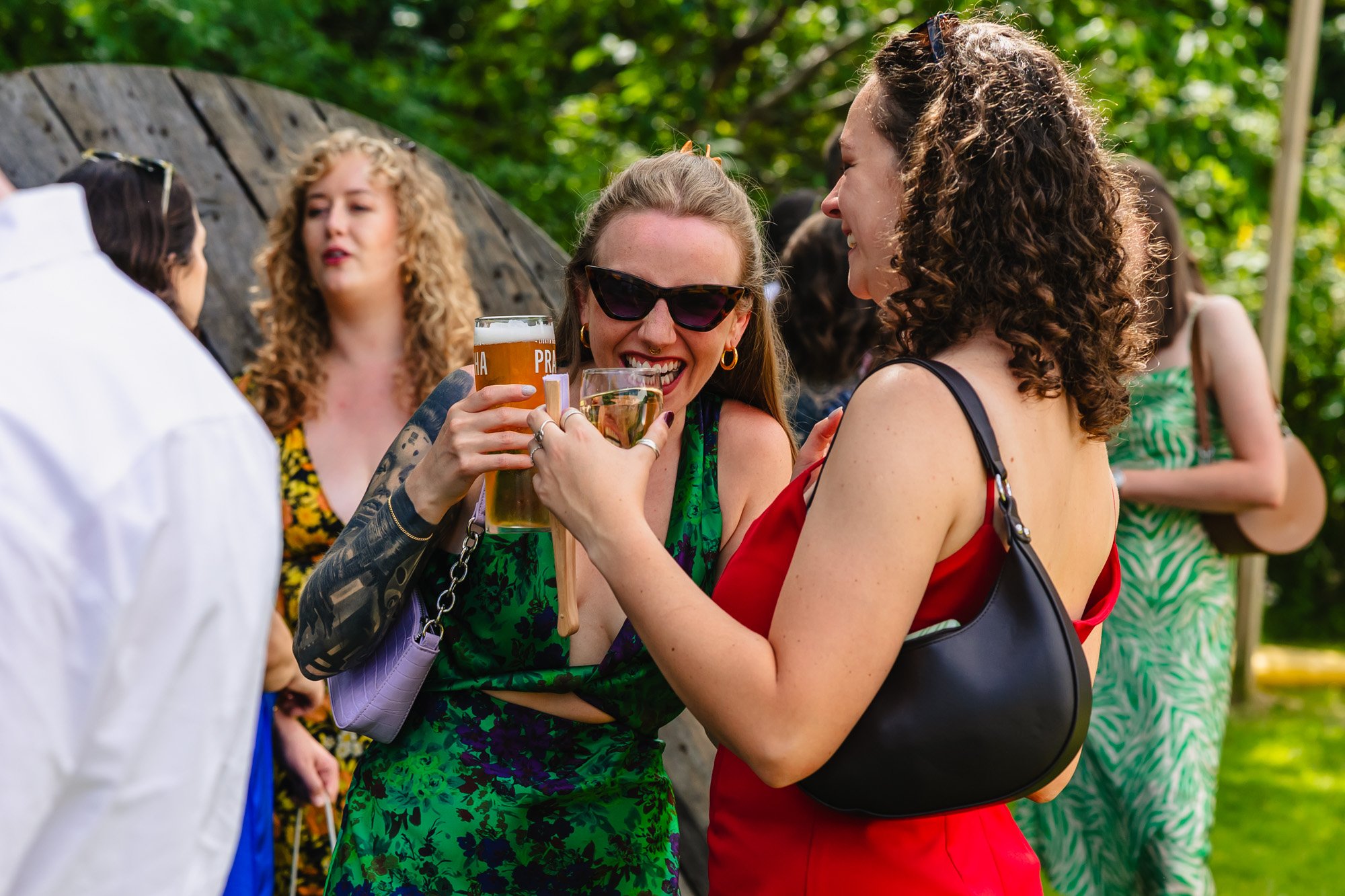 candid wedding photograph of guests laughing and drinking at a wedding reception in Manchester