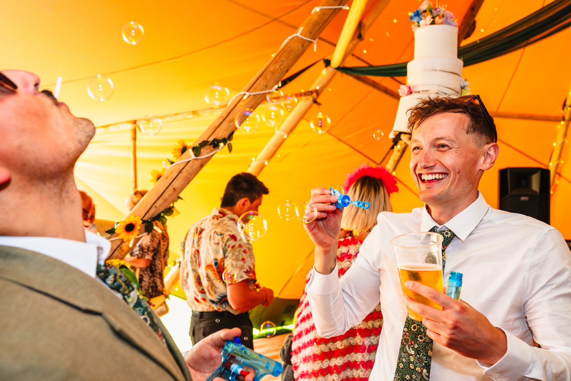 photograph of two groomsmen blowing bubbles and giggling