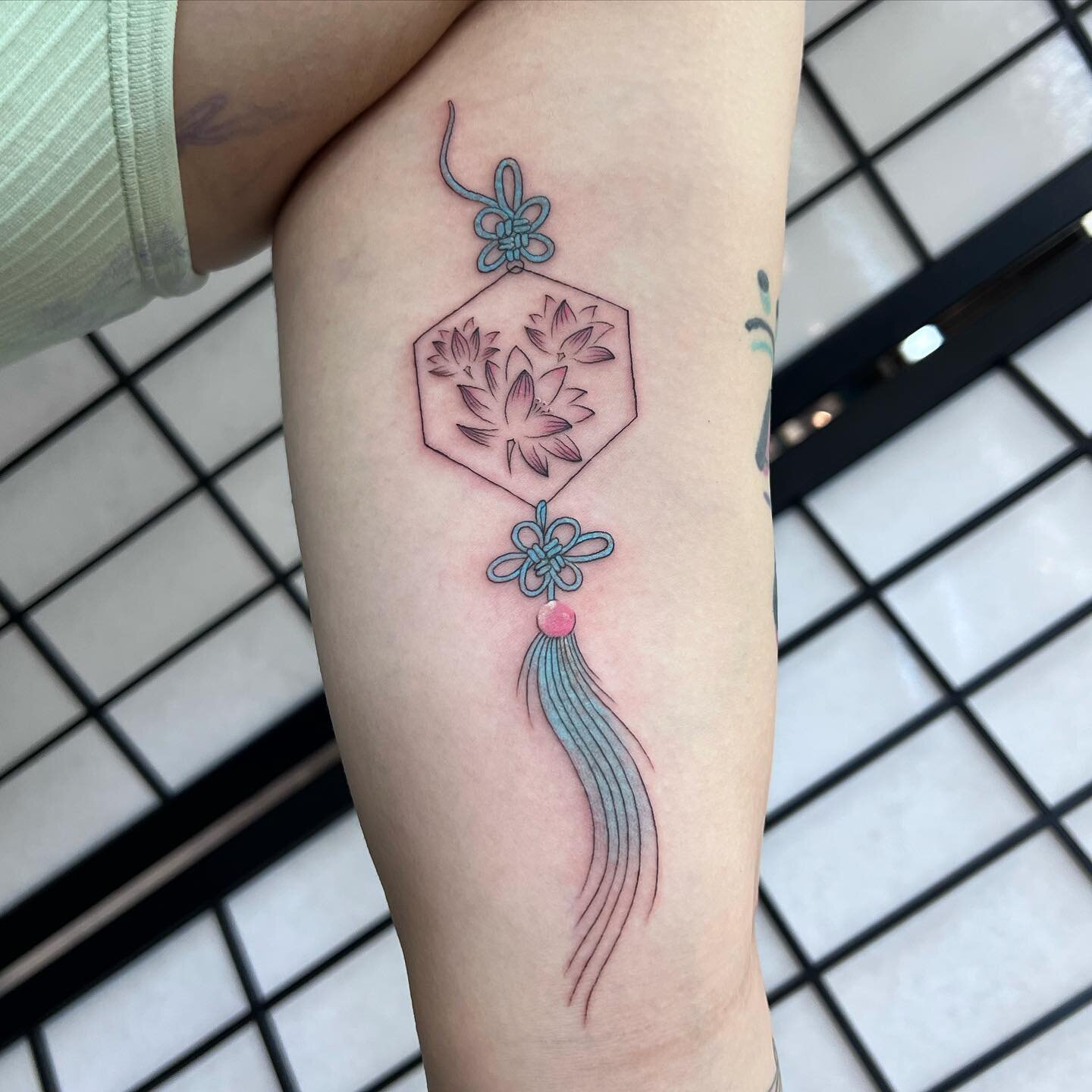 Fine line pastel pink and blue charm with lotus flowers! 🪷✨ #queer #queerart #queerartist #queertattooer #queertattooartist #qttr #milwaukee #milwaukeetattoo #milwaukeetattoos #milwaukeetattooartist #wisconsintattooartists #finelinetattoo #finelinet