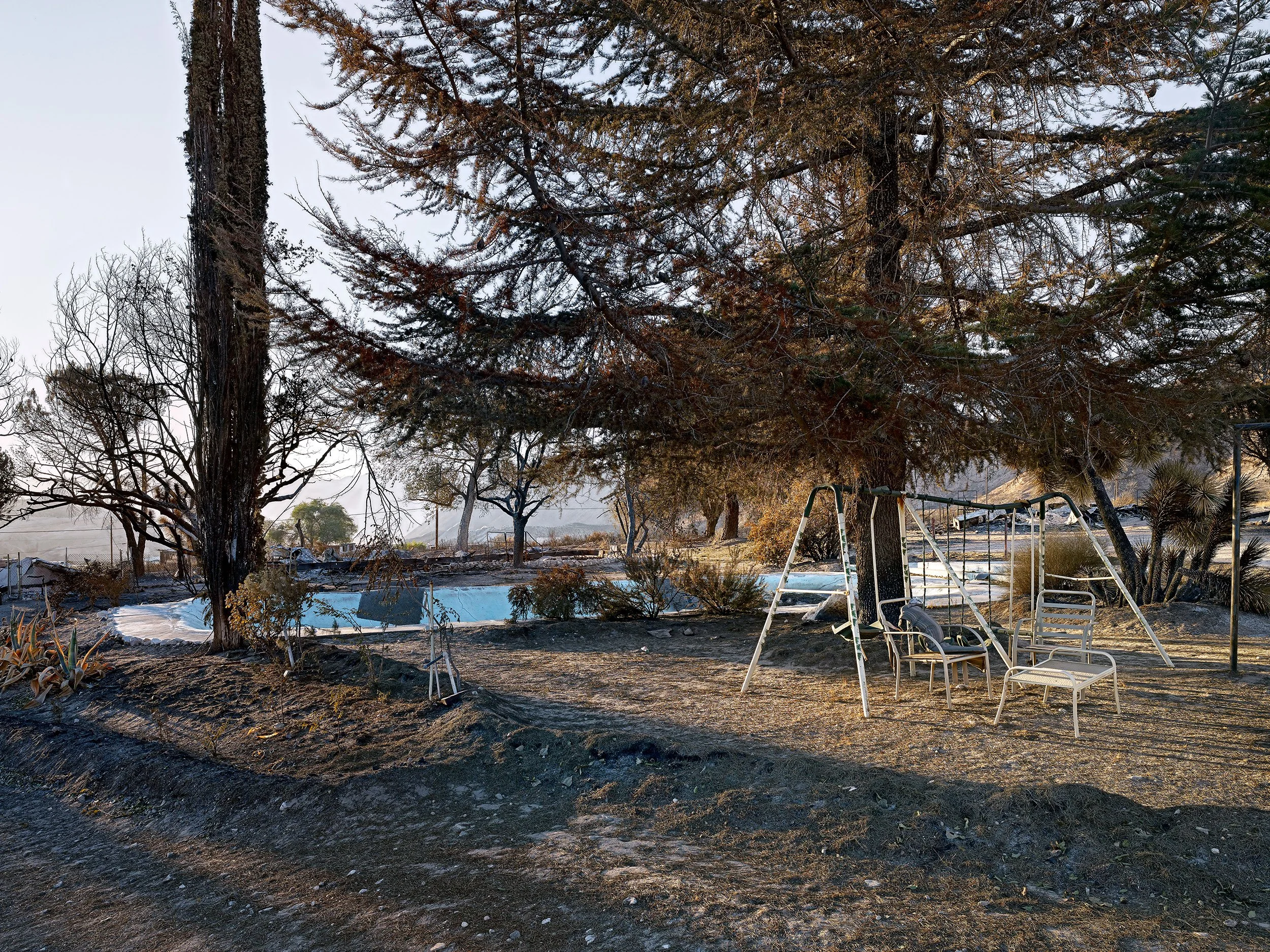 A swing and pool at a burnt home in California, part of the Lost America series; a finalist at the Belfast Photo Festival.
