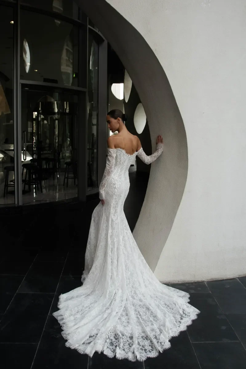 Back view of Kaystine fitted mermaid wedding gown with semi-sheer lace skirt and scalloped train