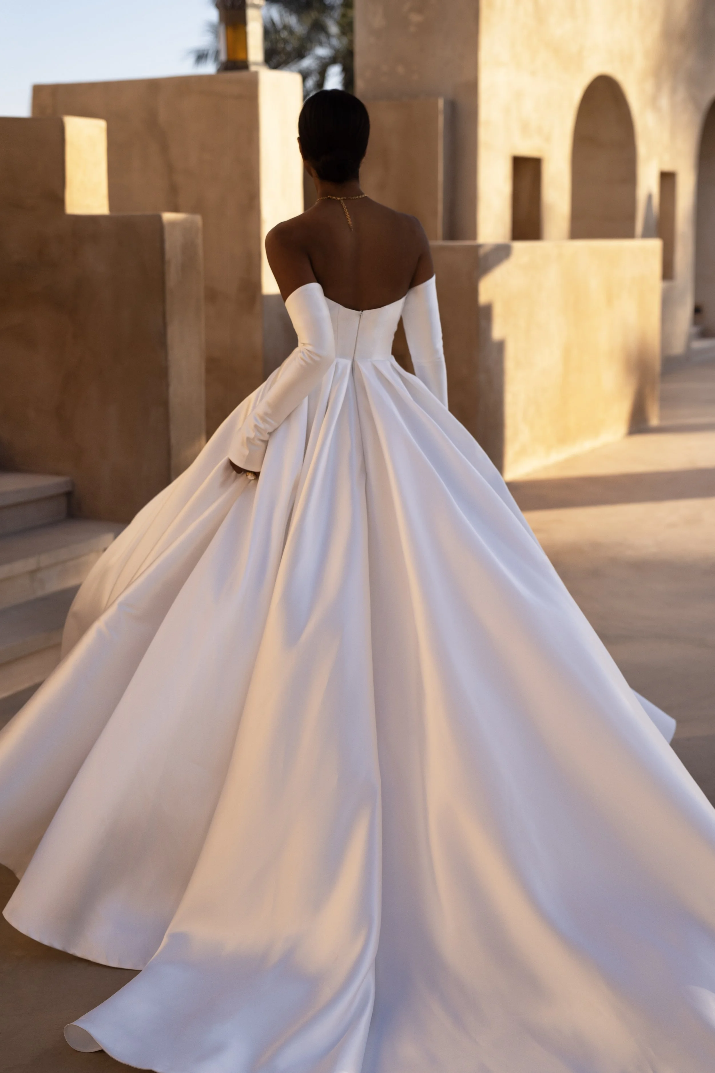 Bride in a Mikado A-Line Wedding Dress with thigh-high slit and removable sleeves, showcasing modern elegance