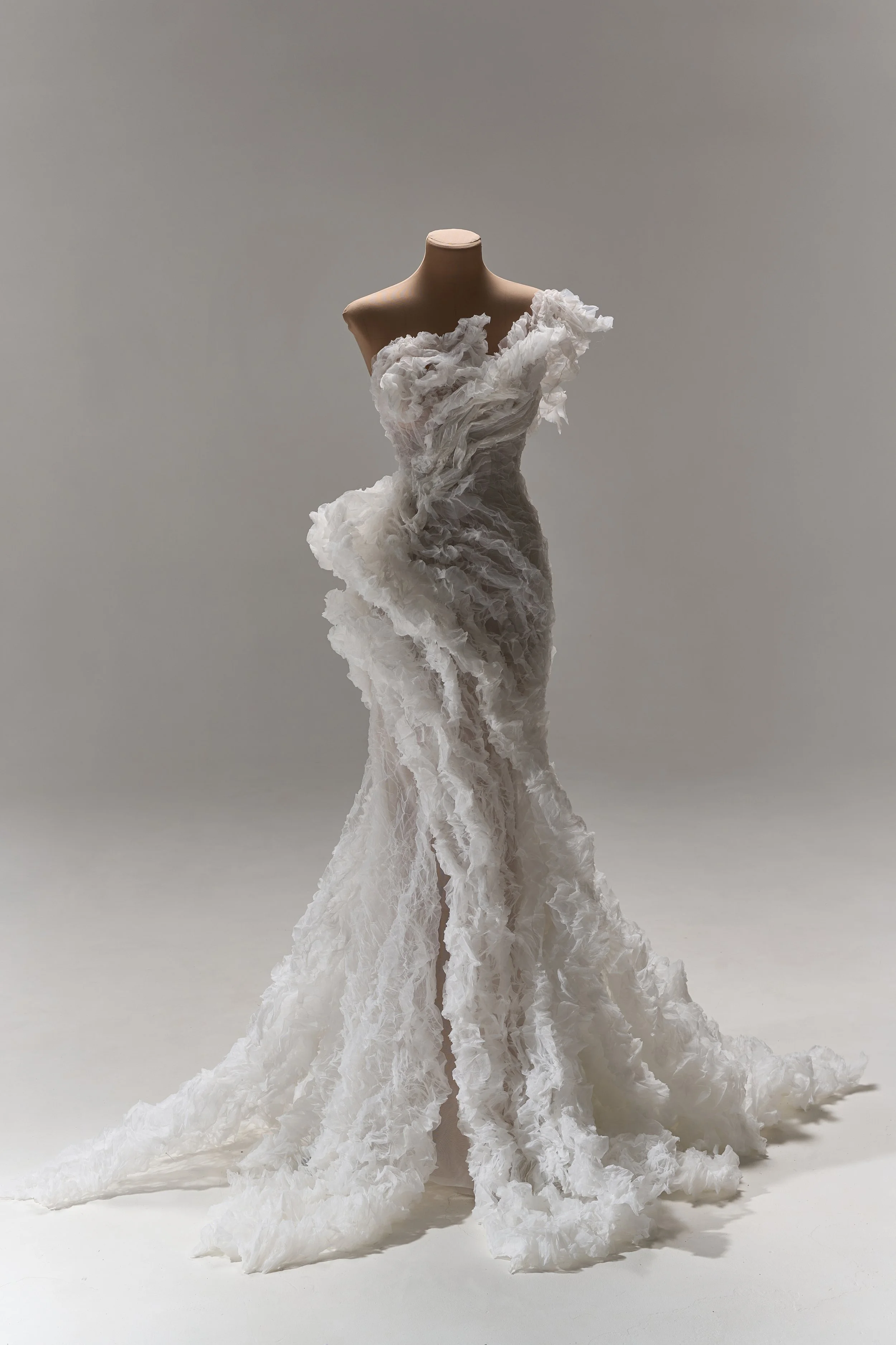 Lana Marinenko sculptural one-shoulder wedding dress with cascading ruffles, fitted silhouette, and sweeping train — a couture bridal gown for modern, fashion-forward brides