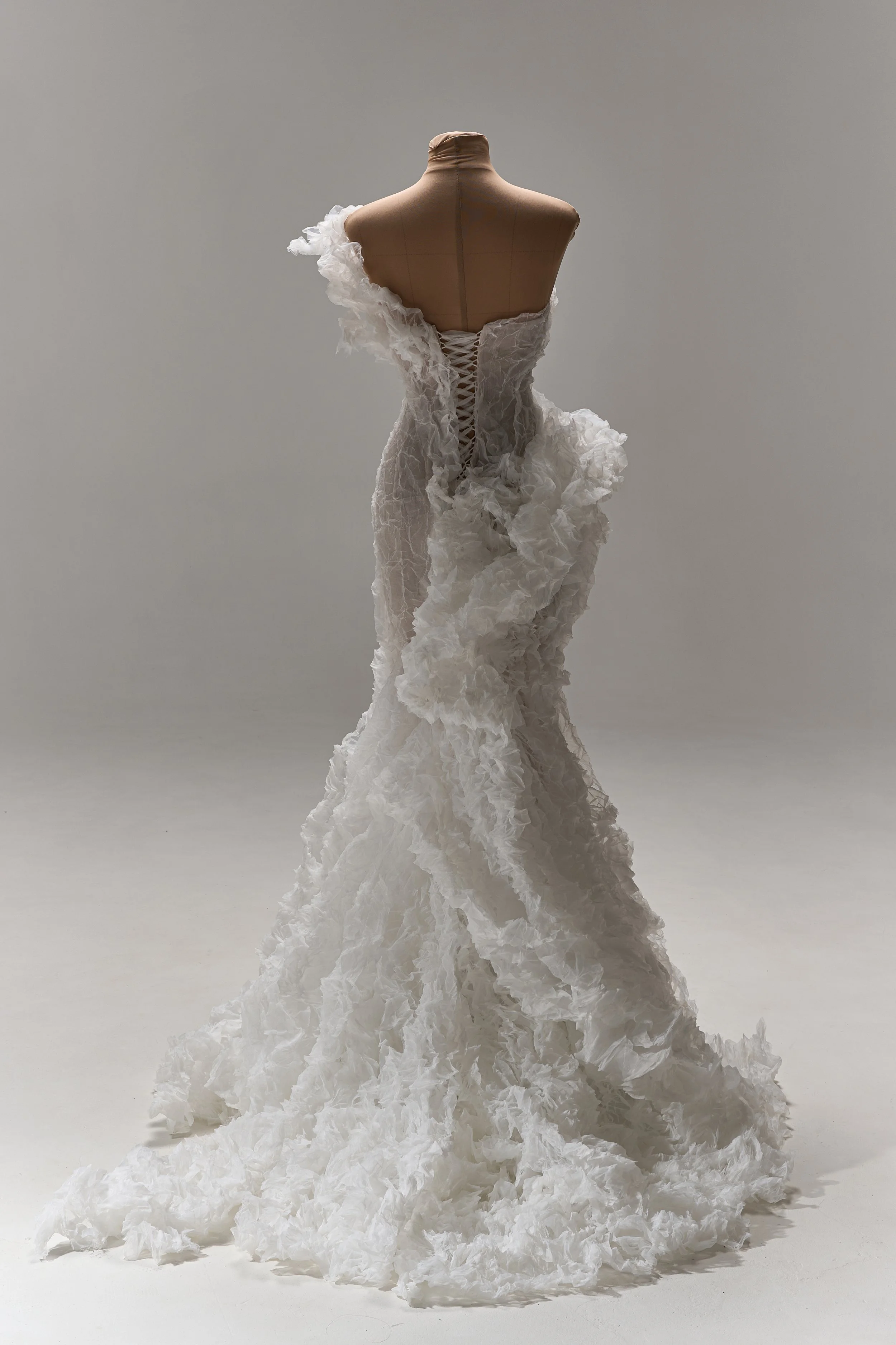 Lana Marinenko sculptural one-shoulder wedding dress with cascading ruffles, fitted silhouette, and sweeping train — a couture bridal gown for modern, fashion-forward brides