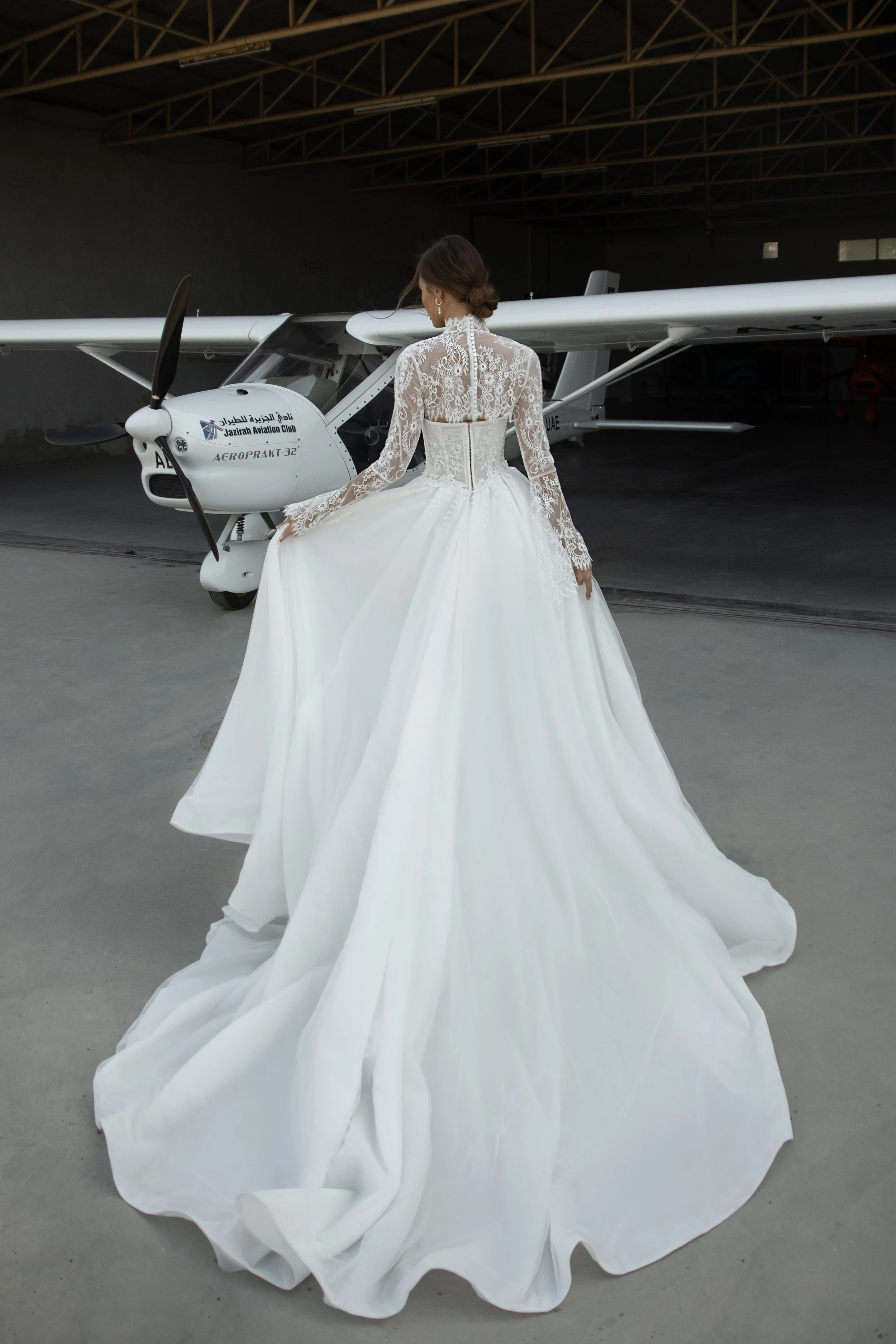 Bride wearing the Leontine wedding dress by Romanova Atelier, a lace ball gown with dropped waist, full skirt, and removable bolero