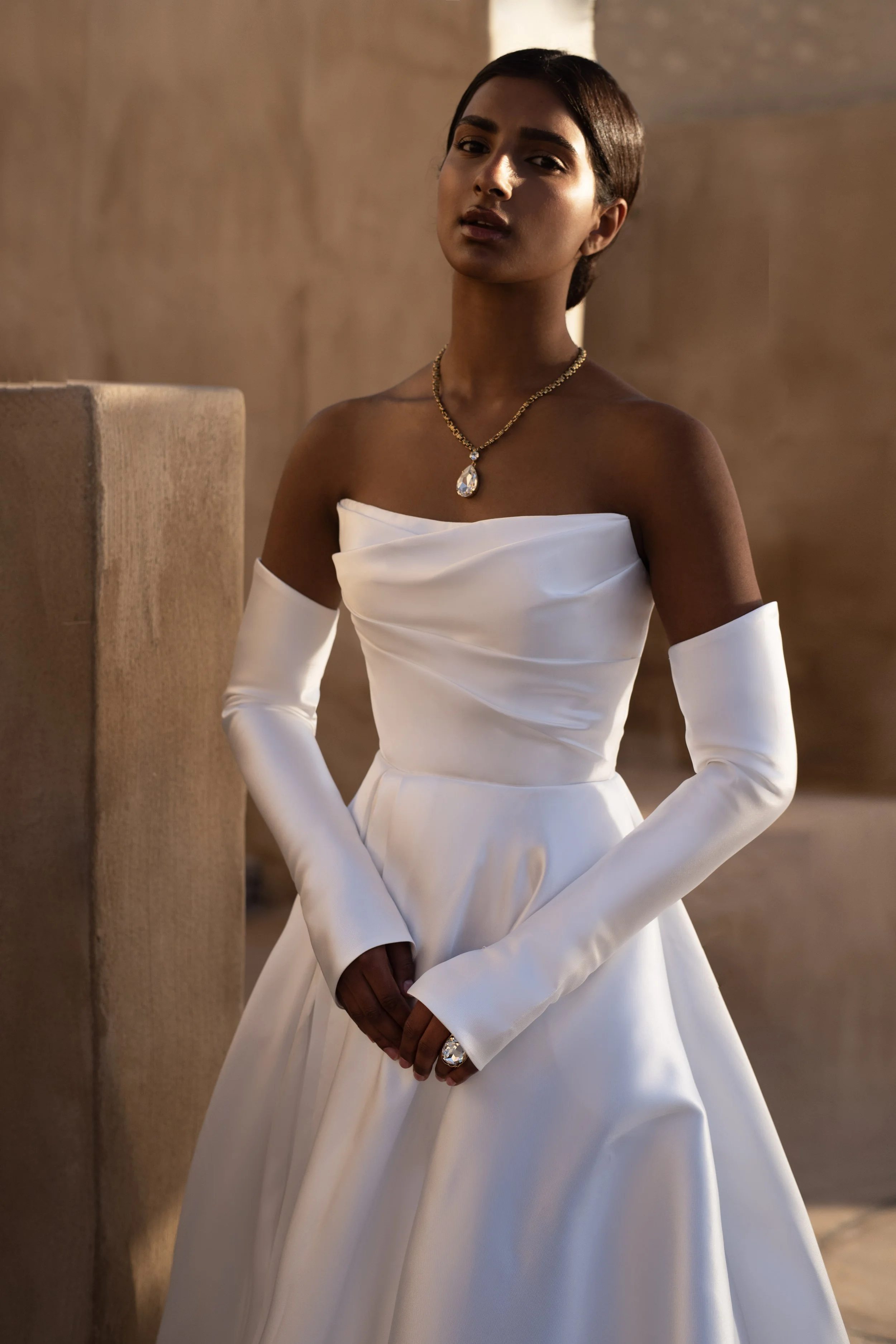 Bride in a Mikado A-Line Wedding Dress with thigh-high slit and removable sleeves, showcasing modern elegance