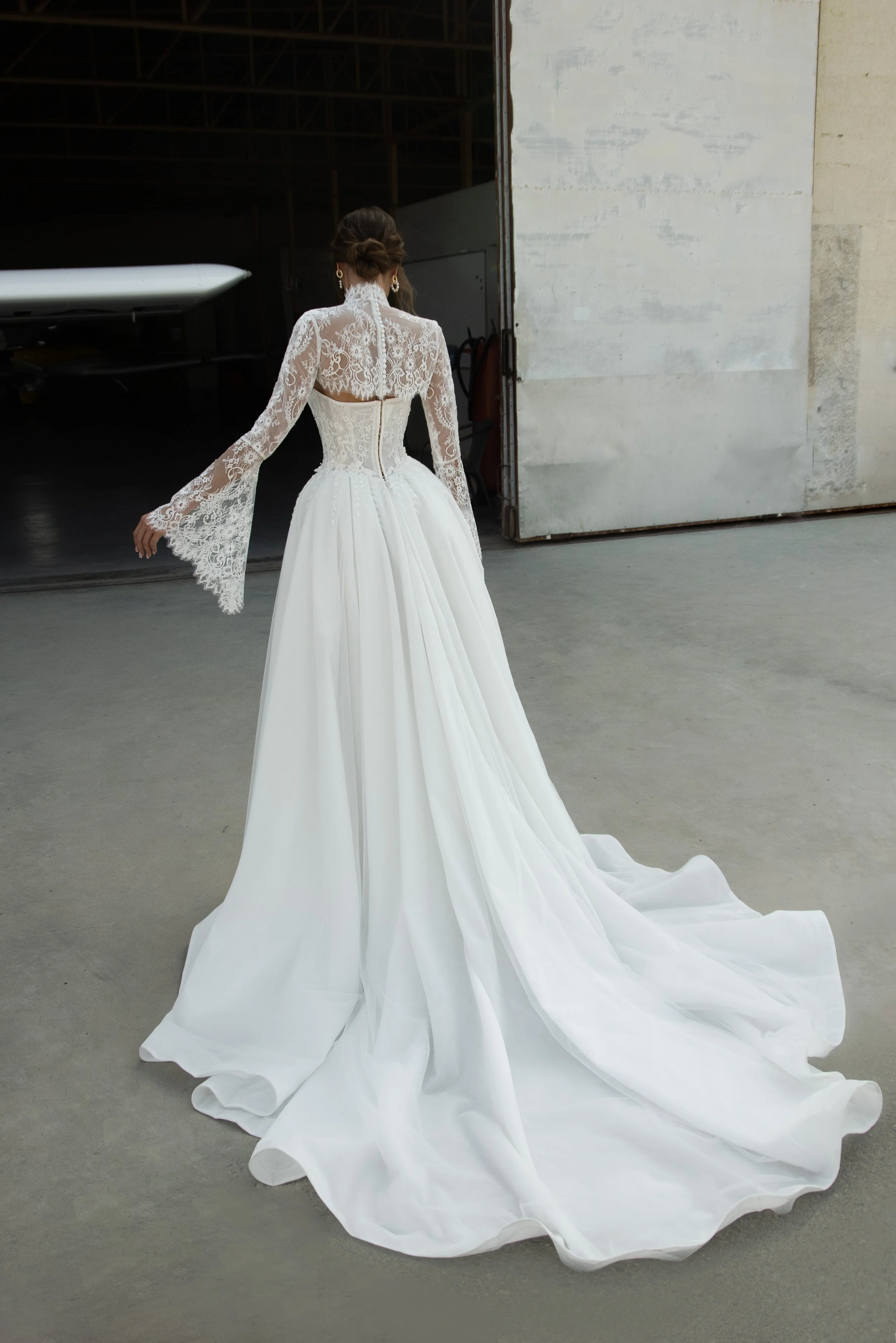 Bride wearing the Leontine wedding dress by Romanova Atelier, a lace ball gown with dropped waist, full skirt, and removable bolero