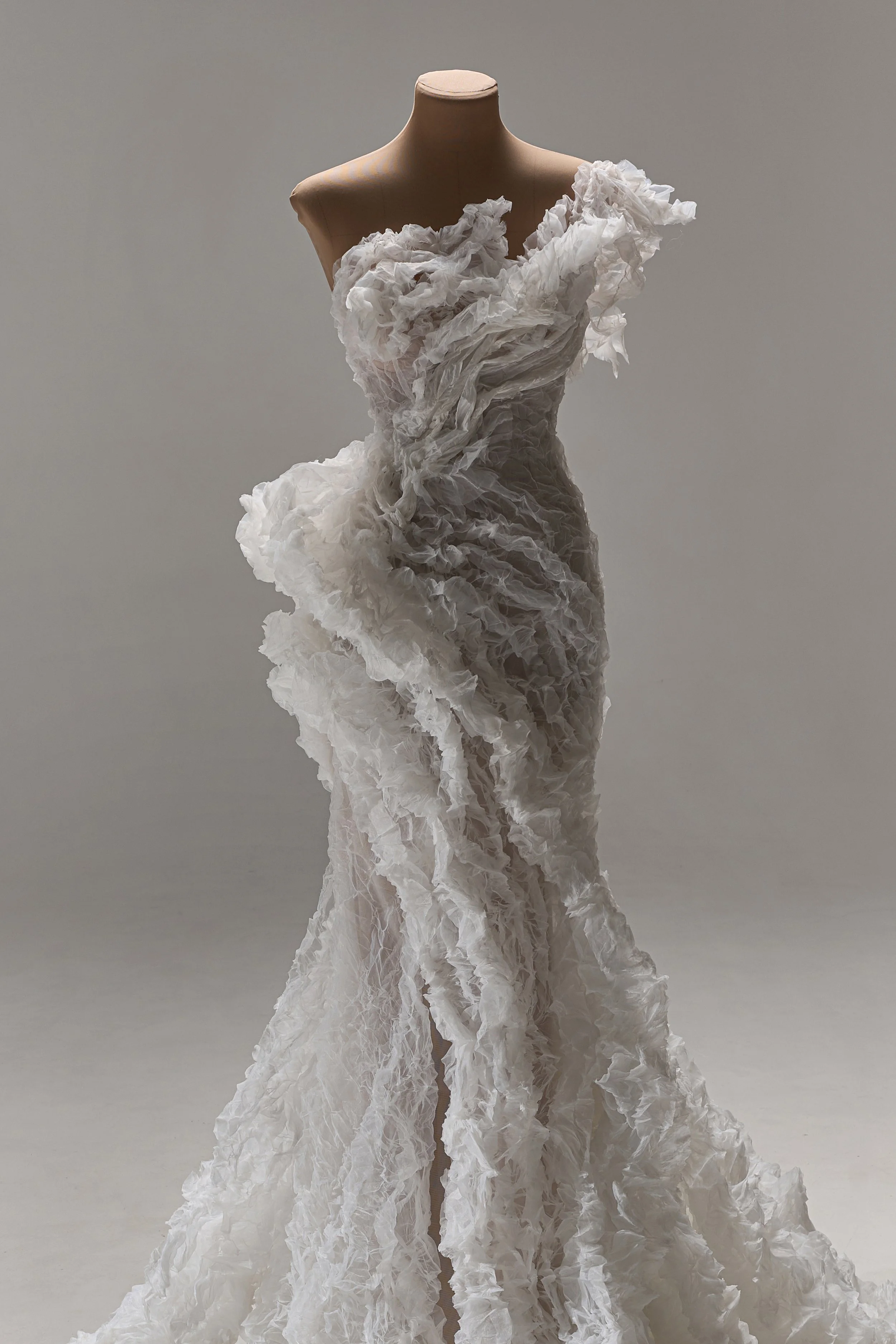 Lana Marinenko sculptural one-shoulder wedding dress with cascading ruffles, fitted silhouette, and sweeping train — a couture bridal gown for modern, fashion-forward brides