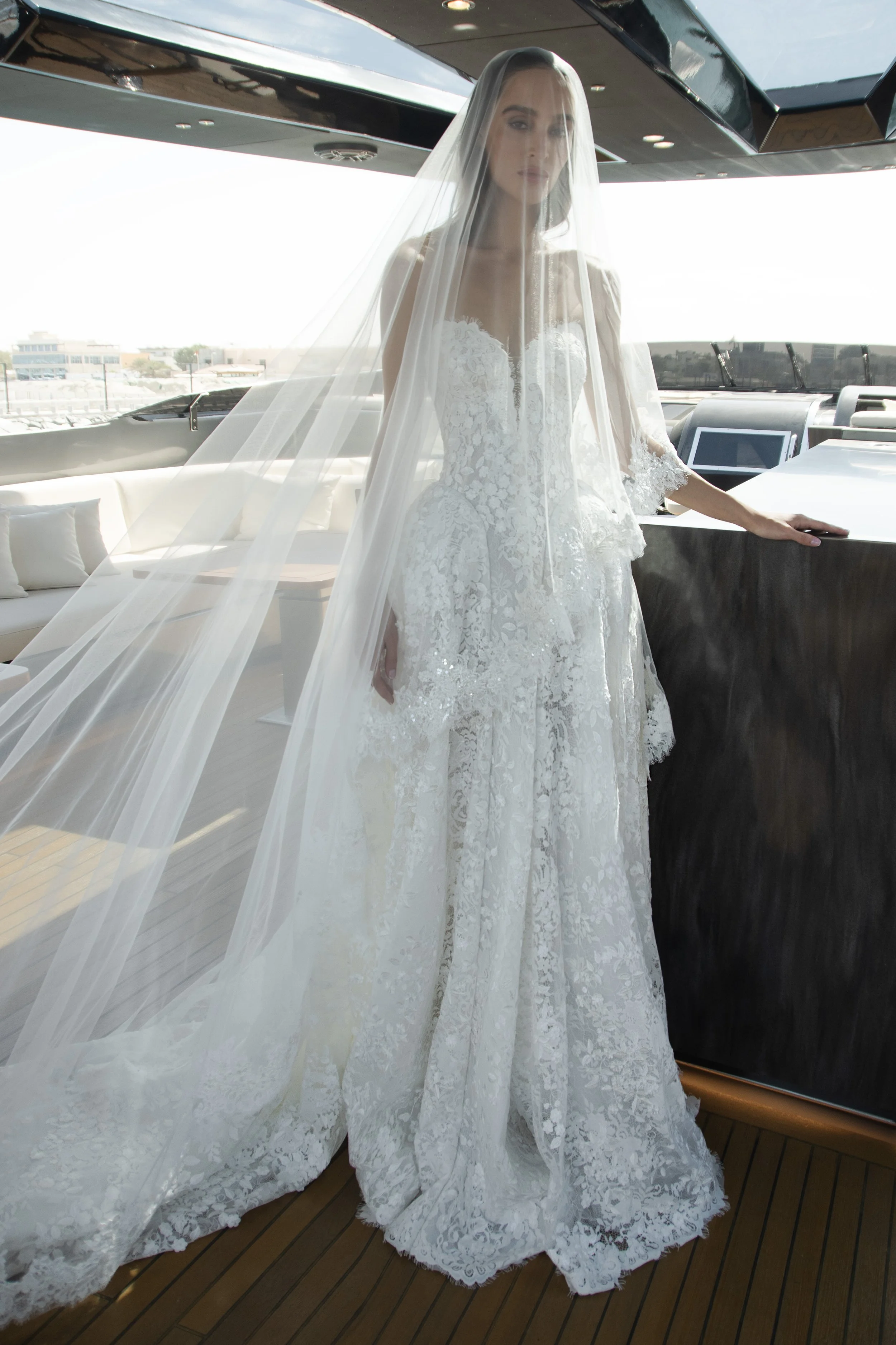 Bride in the Venice gown by Natalia Romanova featuring intricate lace, sheer detailing, and a romantic ball gown silhouette