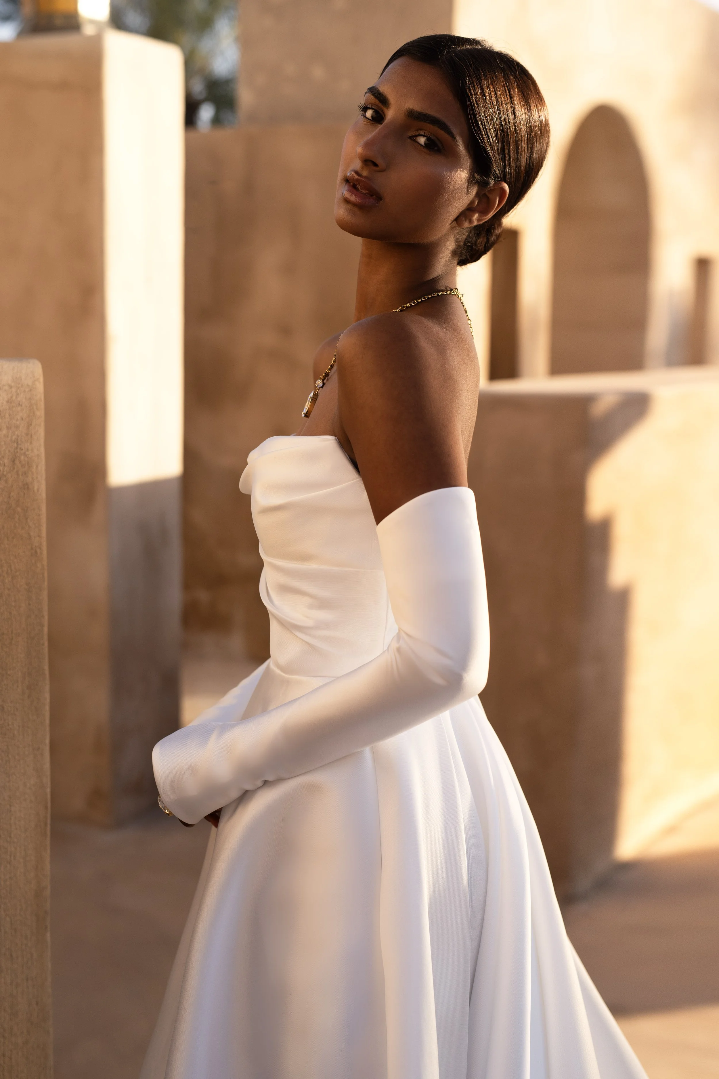 Bride in a Mikado A-Line Wedding Dress with thigh-high slit and removable sleeves, showcasing modern elegance