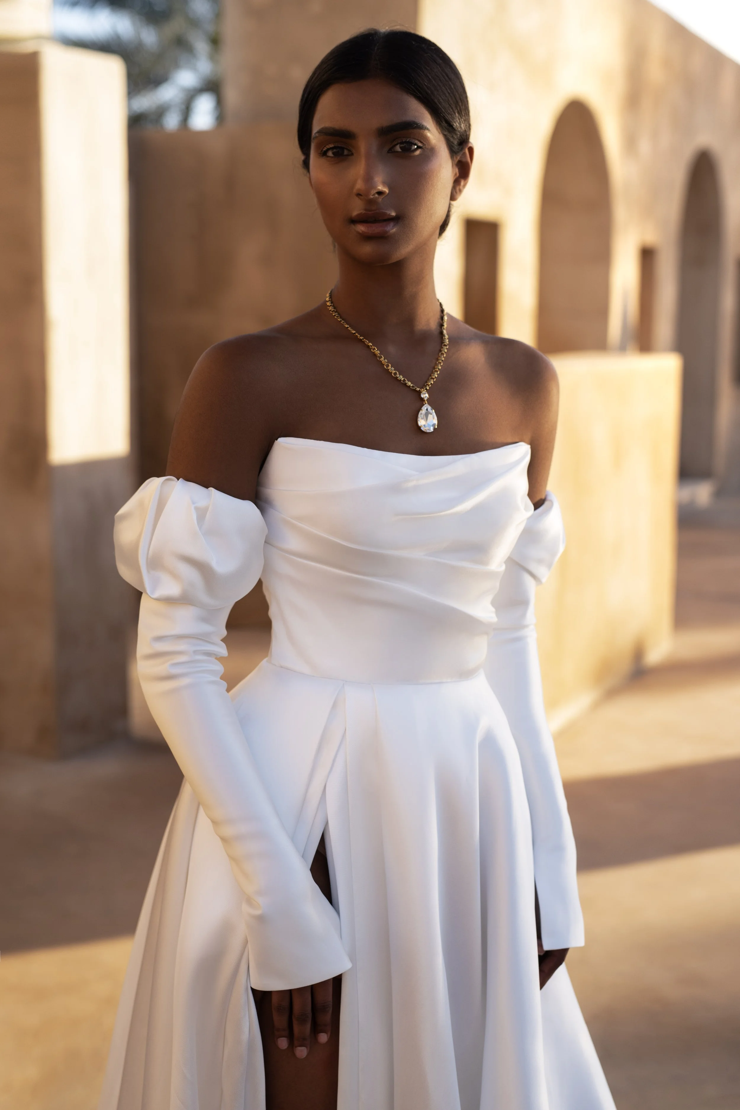 Bride in a Mikado A-Line Wedding Dress with thigh-high slit and removable sleeves, showcasing modern elegance