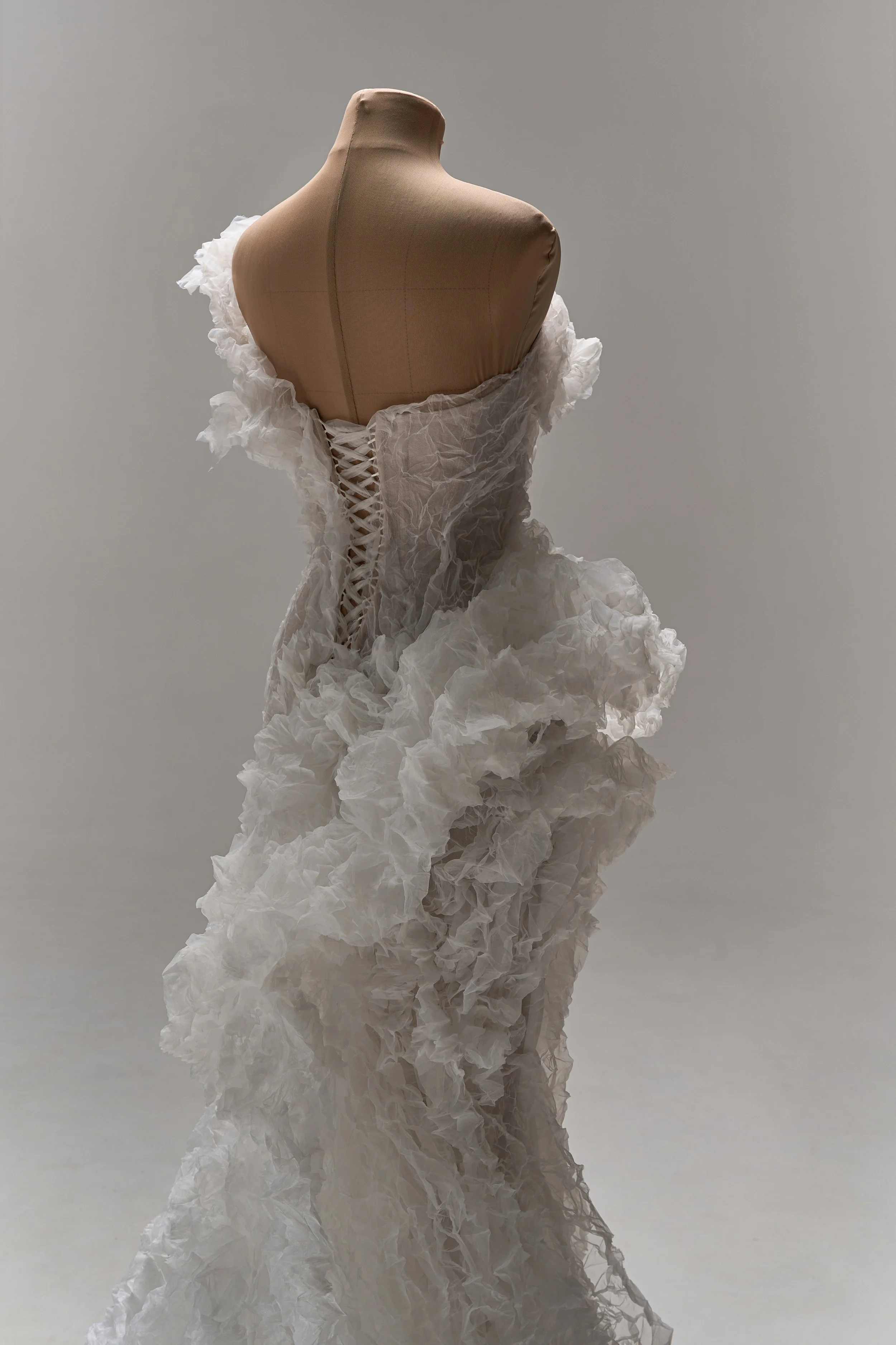Lana Marinenko sculptural one-shoulder wedding dress with cascading ruffles, fitted silhouette, and sweeping train — a couture bridal gown for modern, fashion-forward brides
