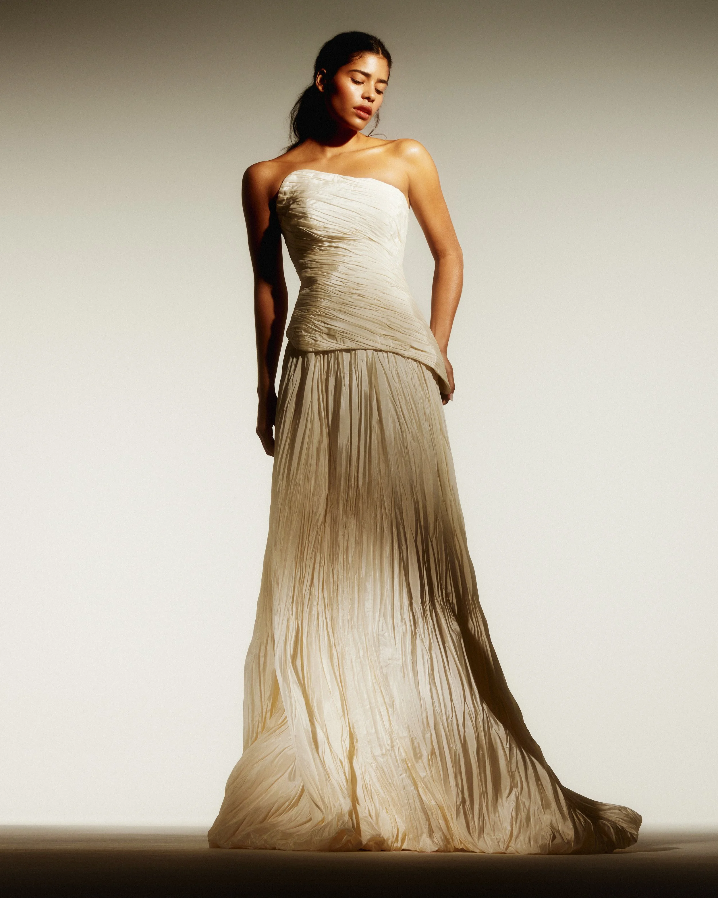 Modern bridal two-piece set in pleated taffeta with asymmetrical top and structured bubble skirt by Rebeca Nepomuceno