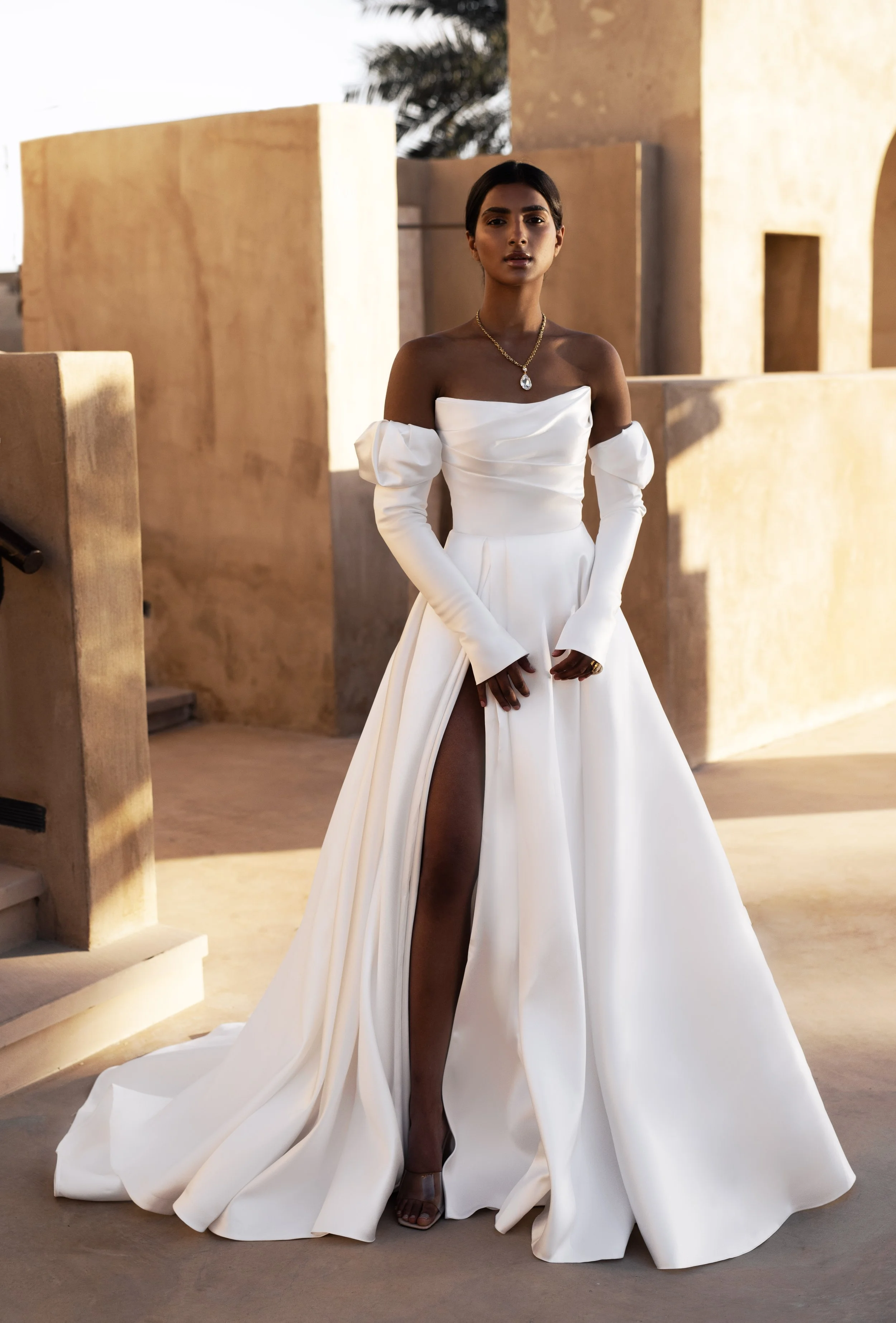 Bride in a Mikado A-Line Wedding Dress with thigh-high slit and removable sleeves, showcasing modern elegance