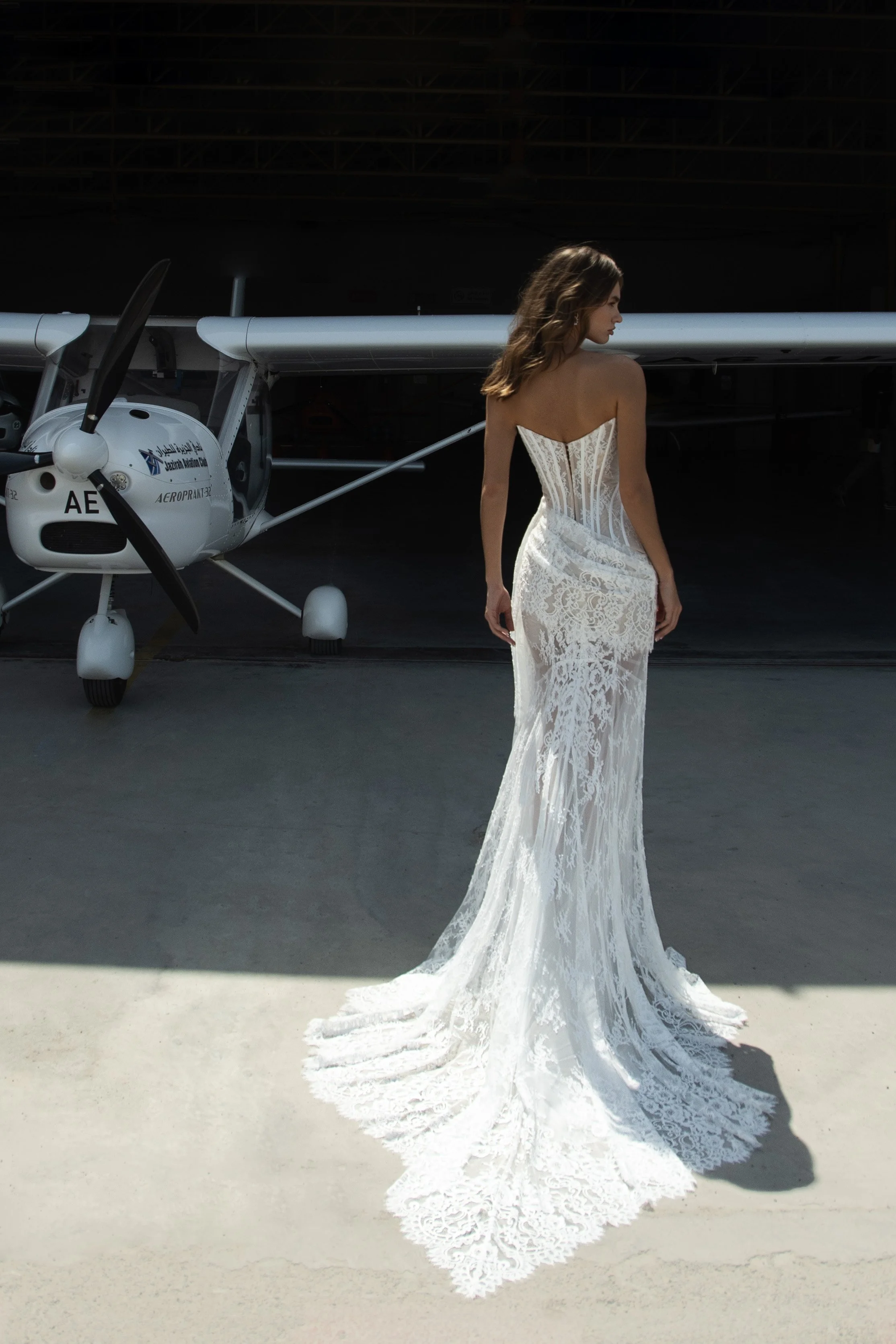 Bride wearing the Jolie wedding dress by Natalia Romanova, a lace sheath gown with strapless corset bodice and removable long skirt