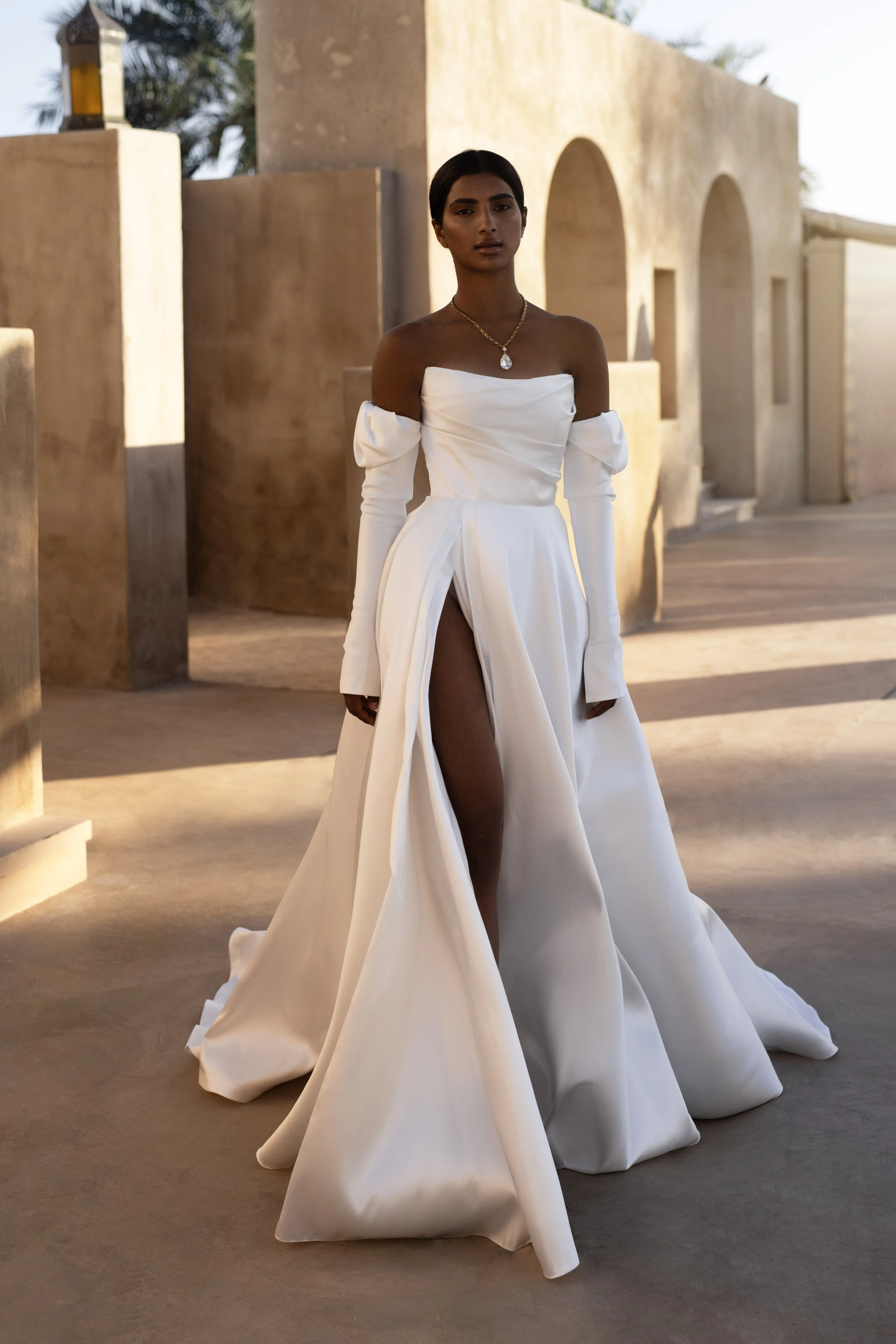 Bride in a Mikado A-Line Wedding Dress with thigh-high slit and removable sleeves, showcasing modern elegance