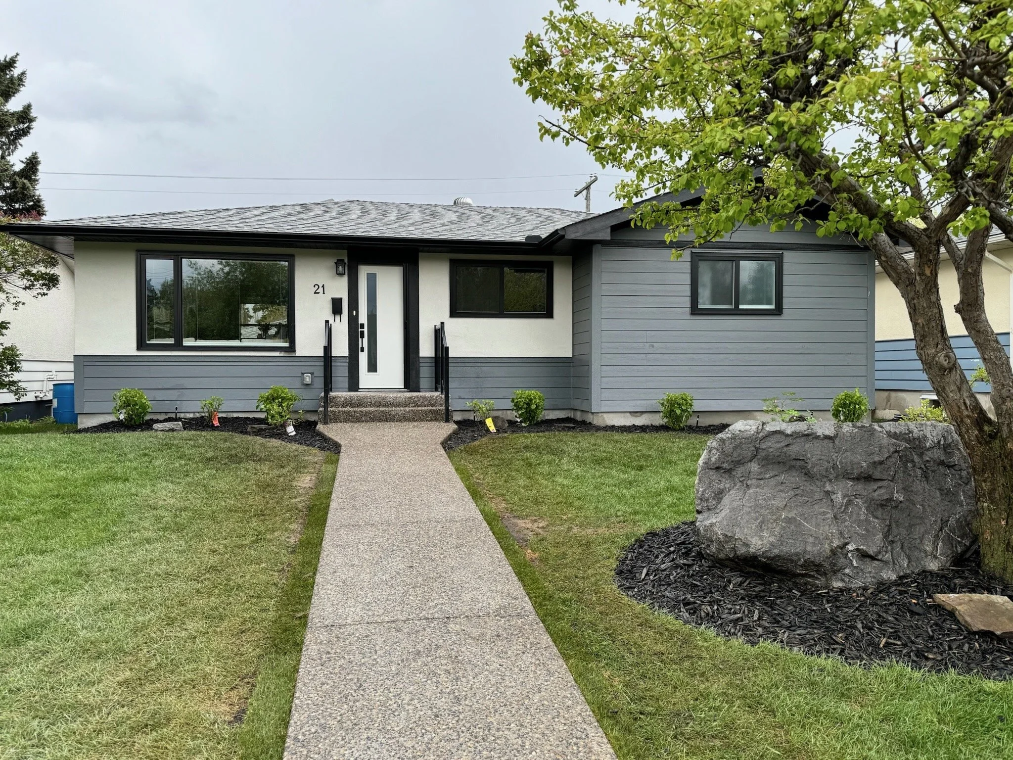 Exposed concrete path and steps installation and curved mulch garden bed.
