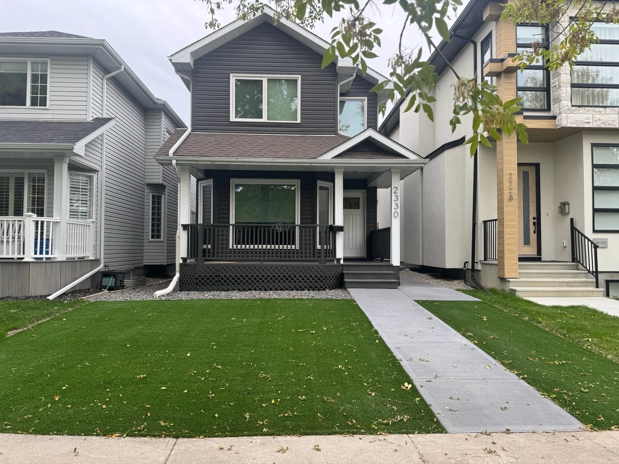 Concrete path and steps, rock garden bed, artificial turf installation, and deck refresh with sanding and painting.