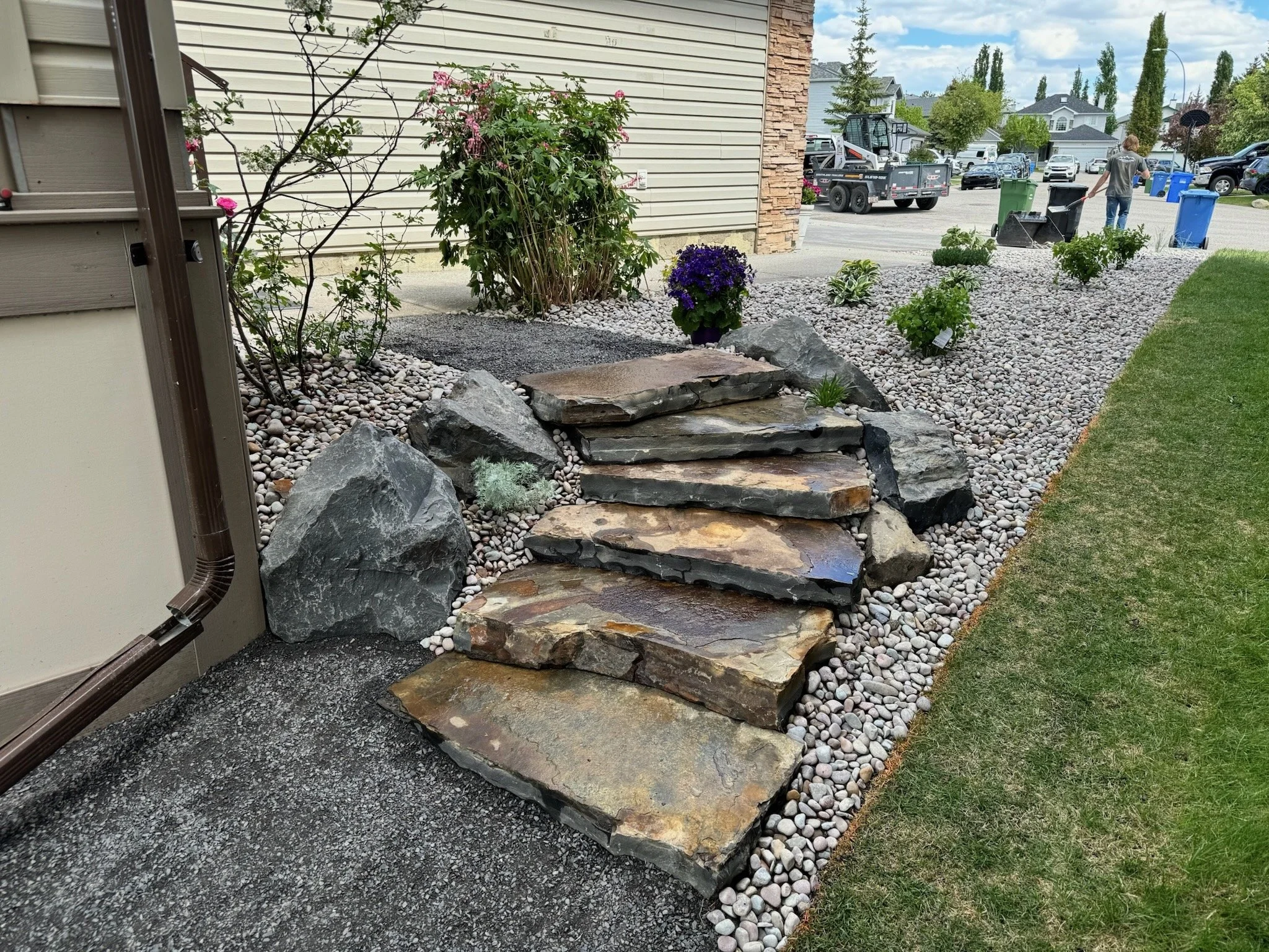 Natural stone and step installation with 10mm rundle path and garden bed border.