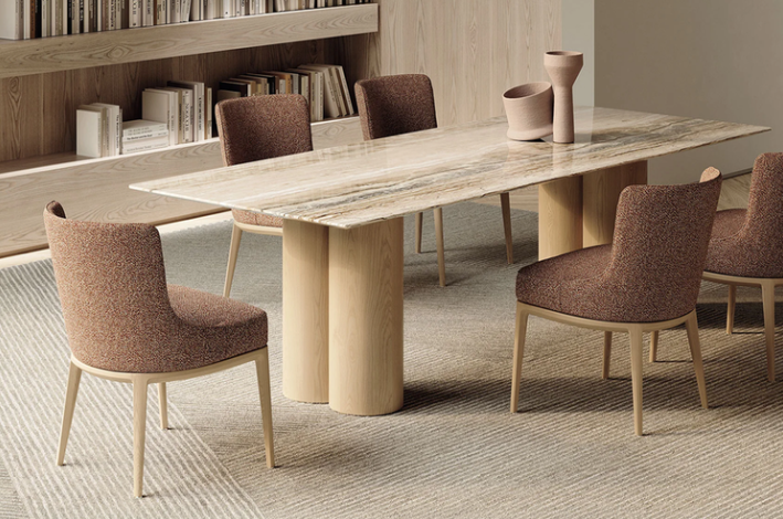 Althea dining chairs featuring textured brown bouclé upholstery and light wooden bases, arranged around a marble-topped dining table with thick wooden column legs.
