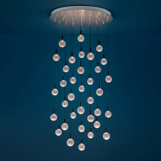 Sypha Spot chandelier with a satin steel base, transparent glass shades, nickel hardware, and black cables.