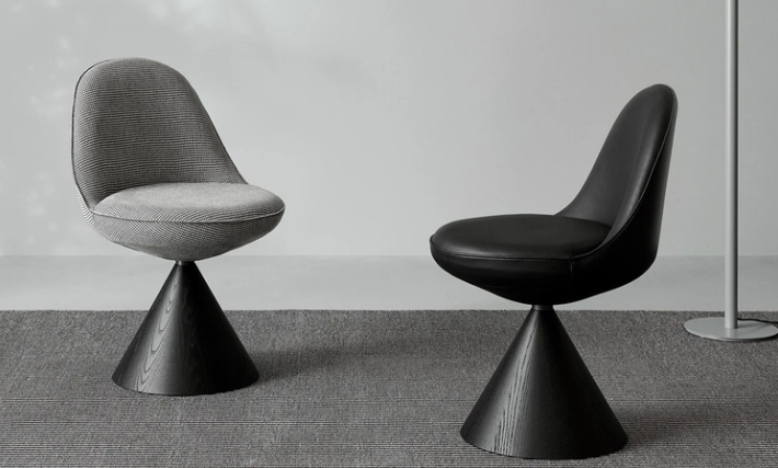 Modern Romby chairs featuring rounded upholstered seats supported by black wooden conical bases, shown in grey patterned fabric and smooth black leather.