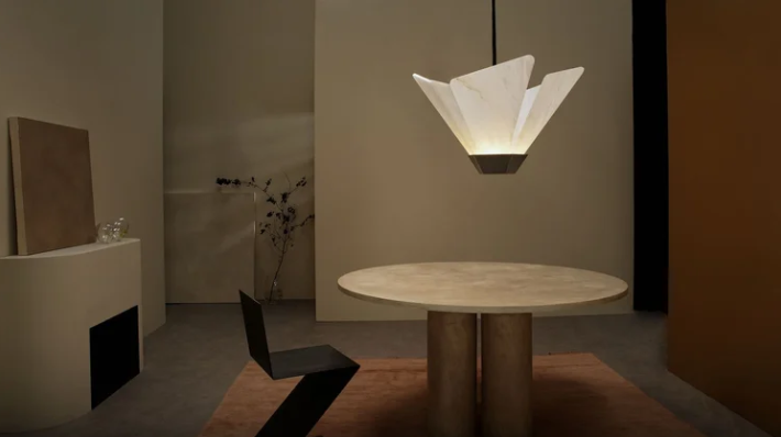 Shard Pendant by CTO Lighting featuring a brass pentagon base in antique bronze paired with a honed alabaster shade, suspended above a dining table.