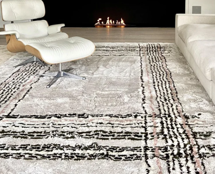Checks rug by JOV, showing a geometric checkered grid pattern hand-crafted from New Zealand wool and Tencel Lyocell in a clean interior setting.